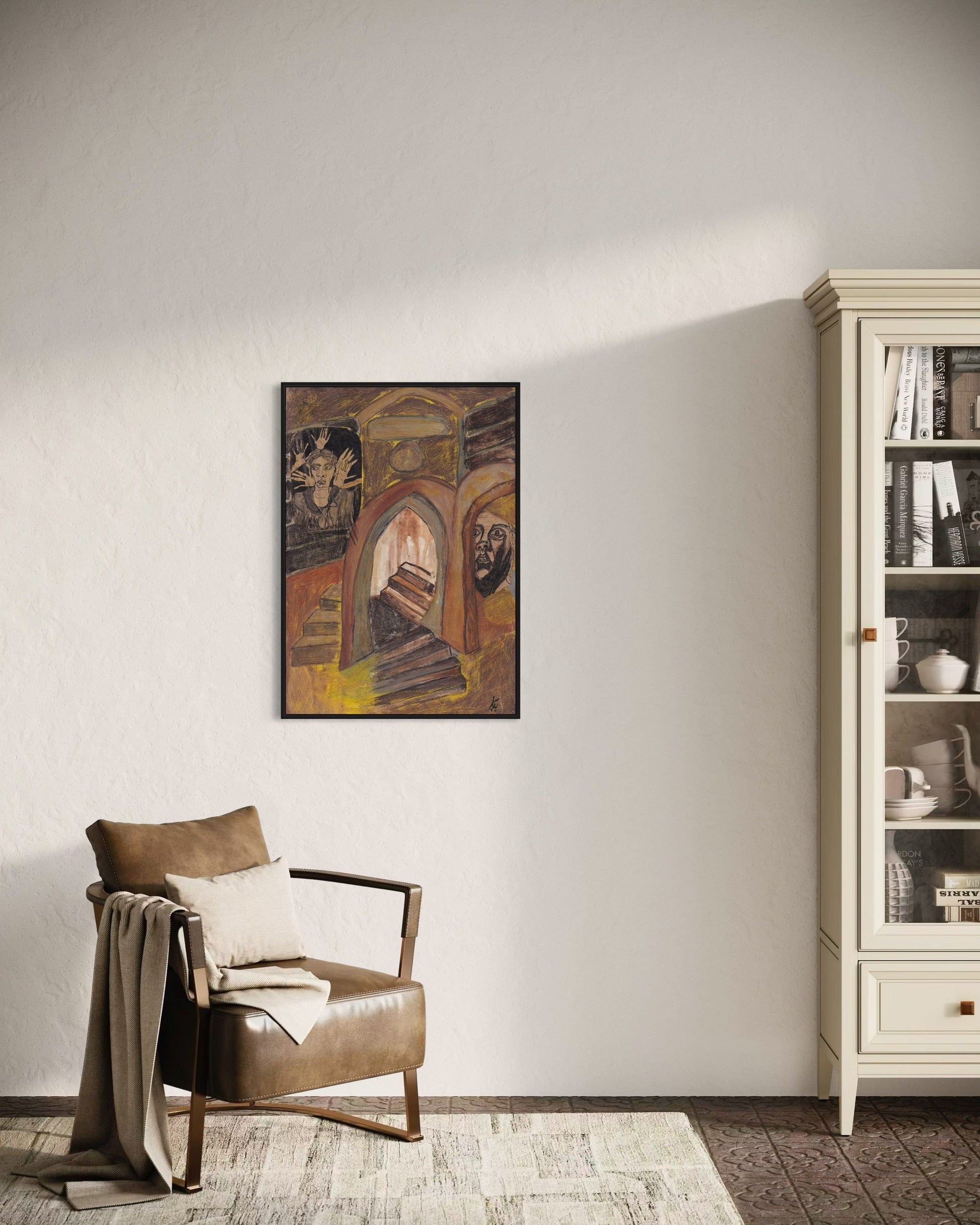 Brown armchair with a blanket and pillow against a white wall with a framed artwork, next to a glass cabinet.