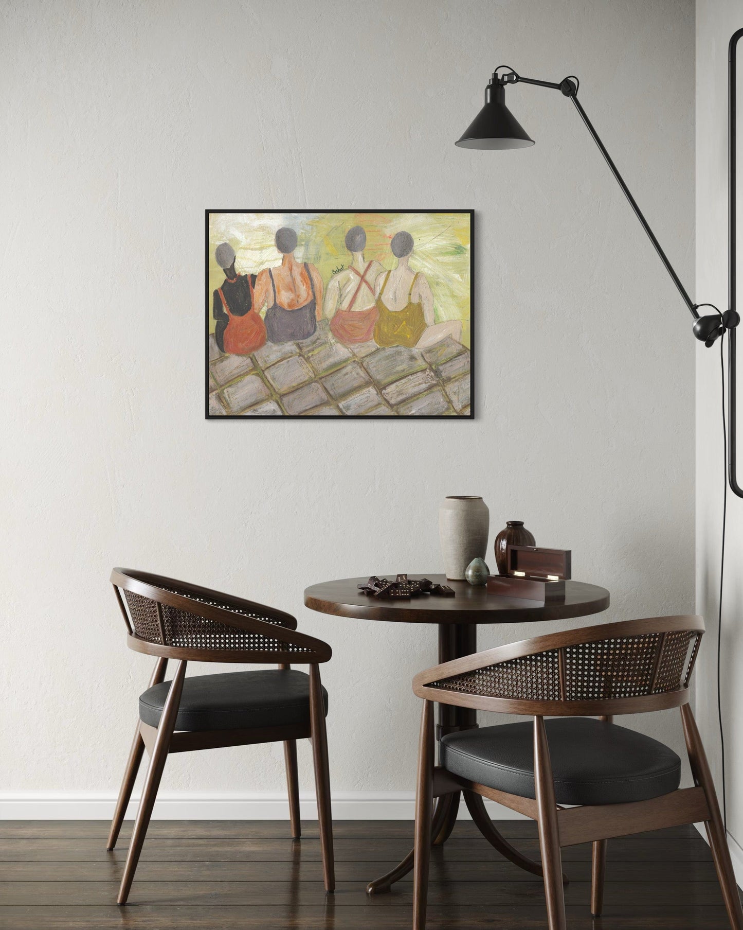 Small dining area with round table and two chairs, wall art, and lamp.