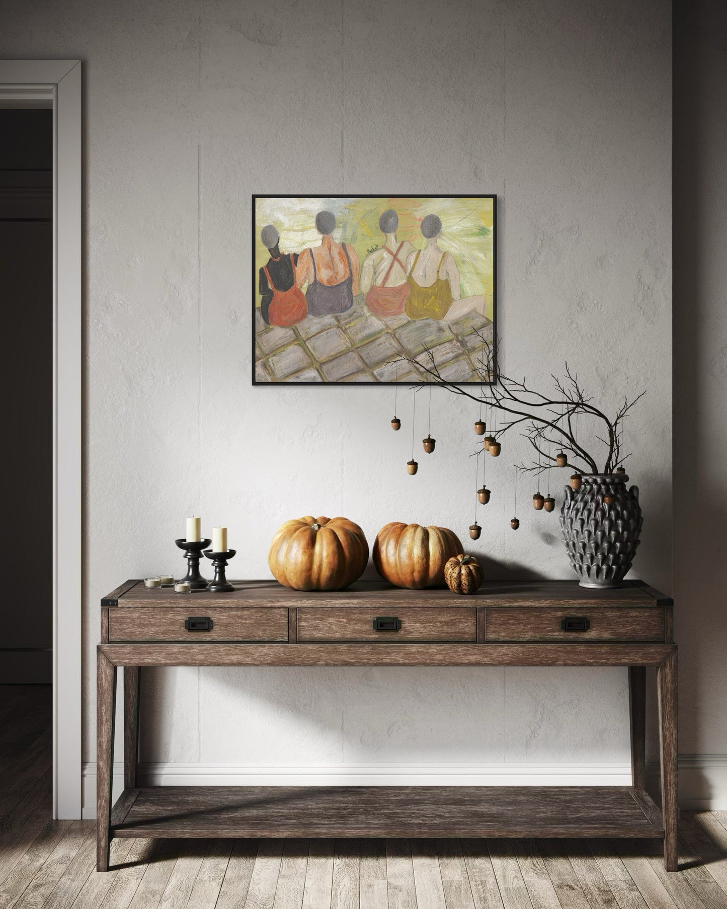 Wooden console table with pumpkins, candles, and a vase against a wall with a framed painting.