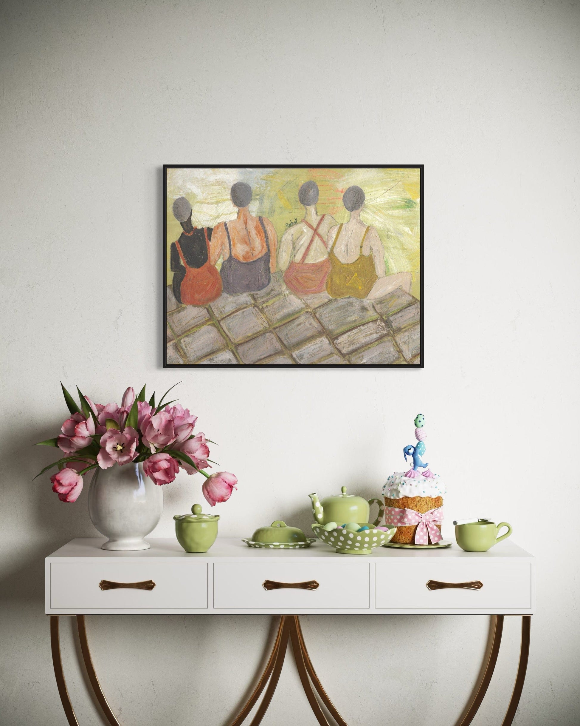 Decorative table with flowers, teapots, and a cake against a wall with a framed painting.