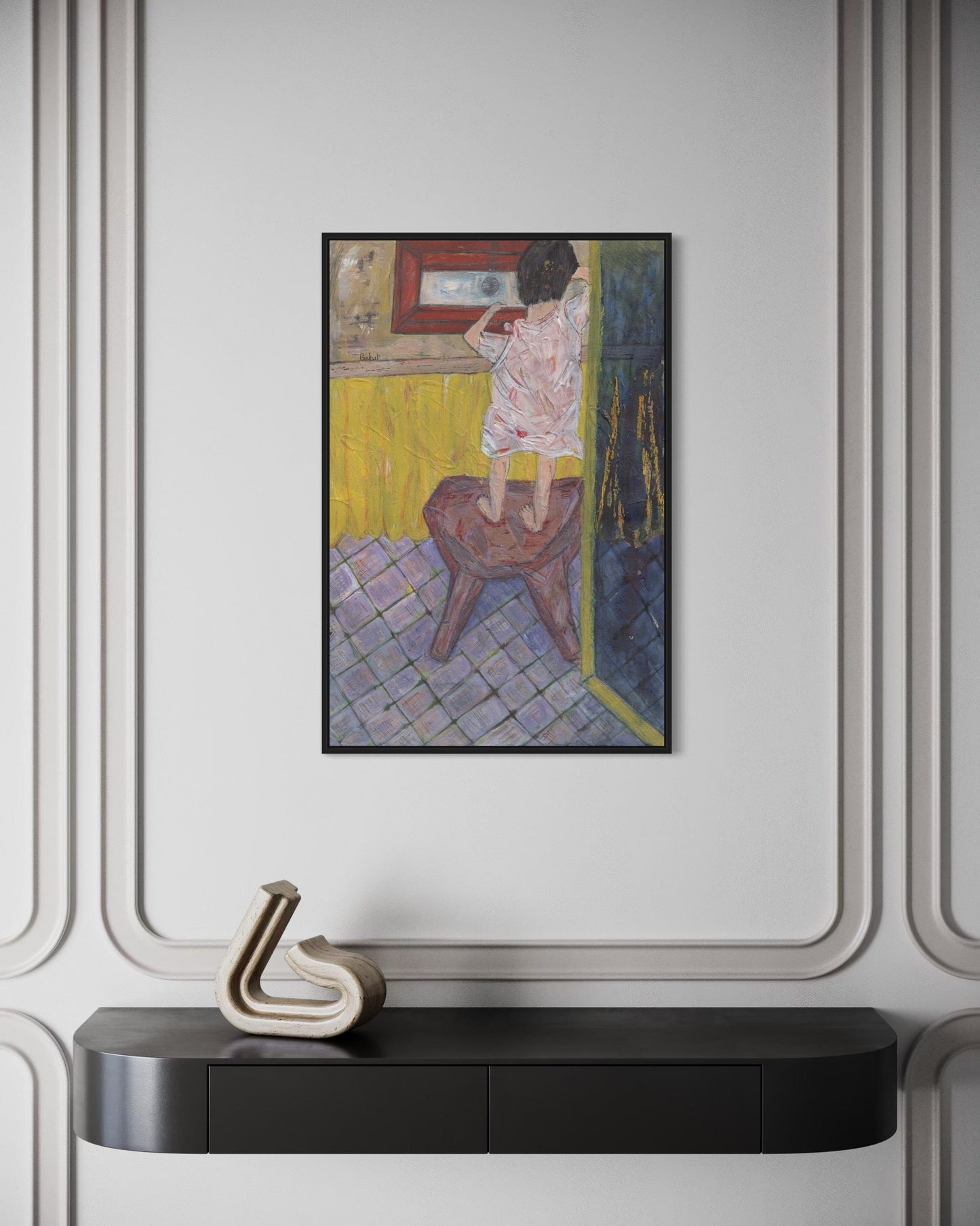 Framed artwork on a wall above a black console table with decorative item.