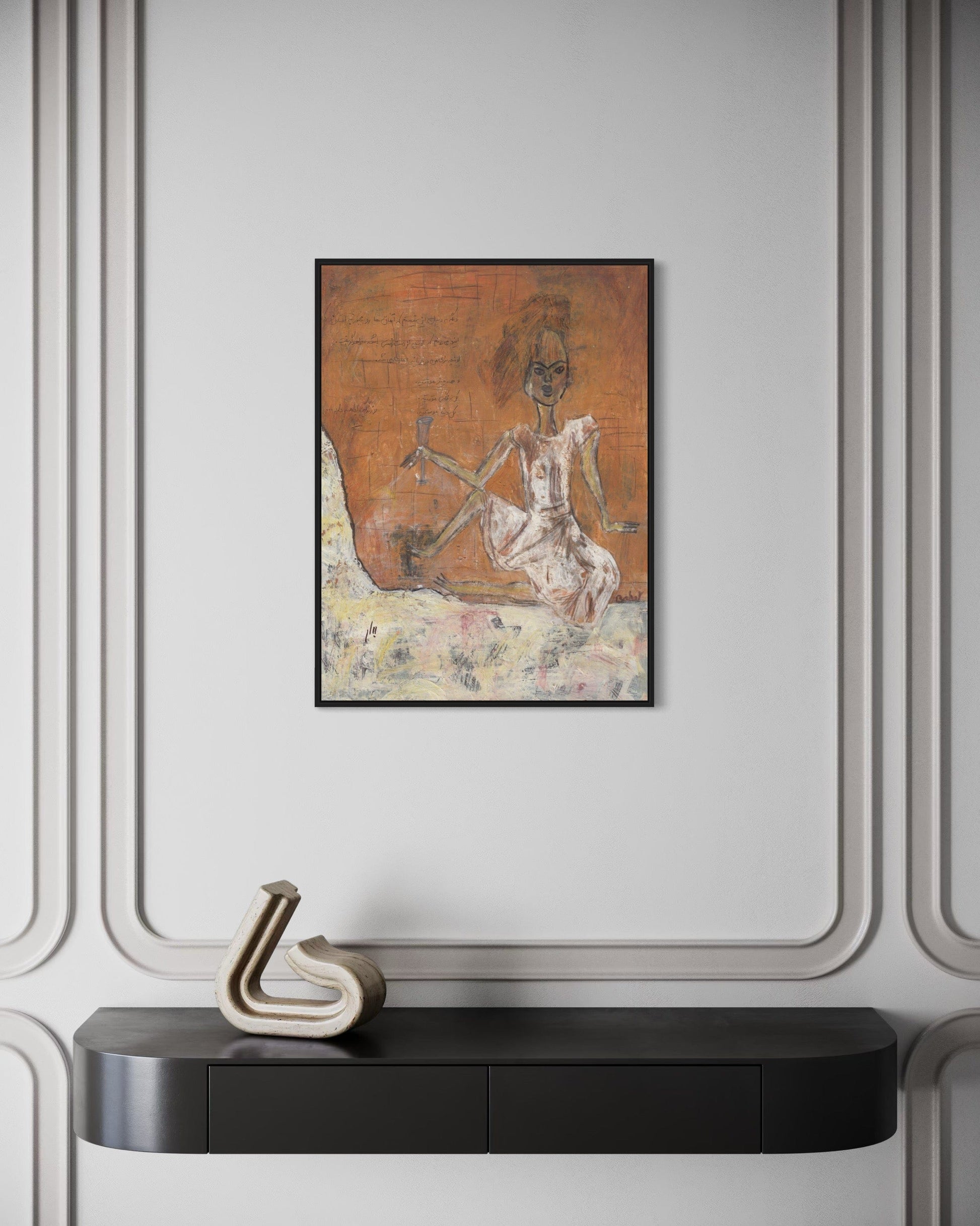 Framed artwork on a wall above a black console table with decorative item.