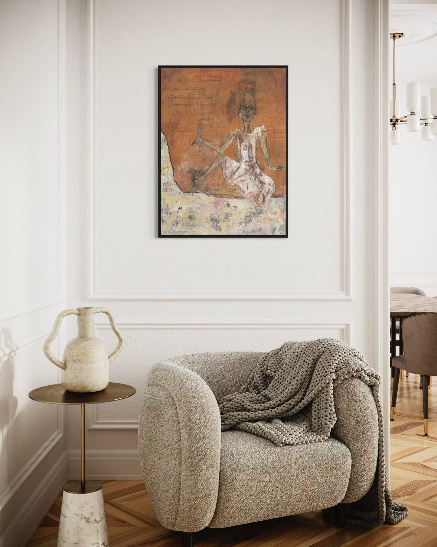 Cozy living room with a plush armchair, side table, and decorative wall art.