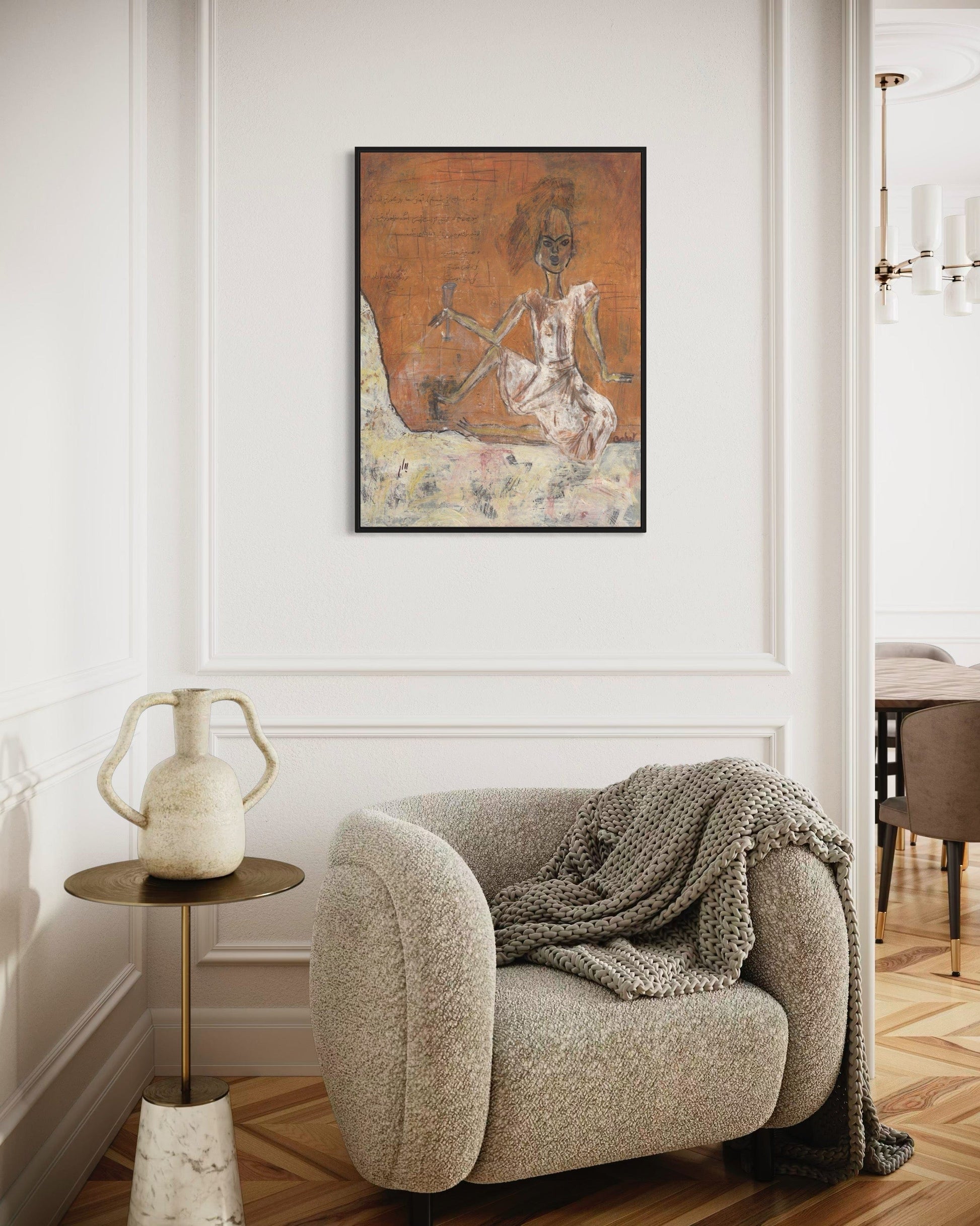 Cozy living room with a plush armchair, side table, and decorative wall art.