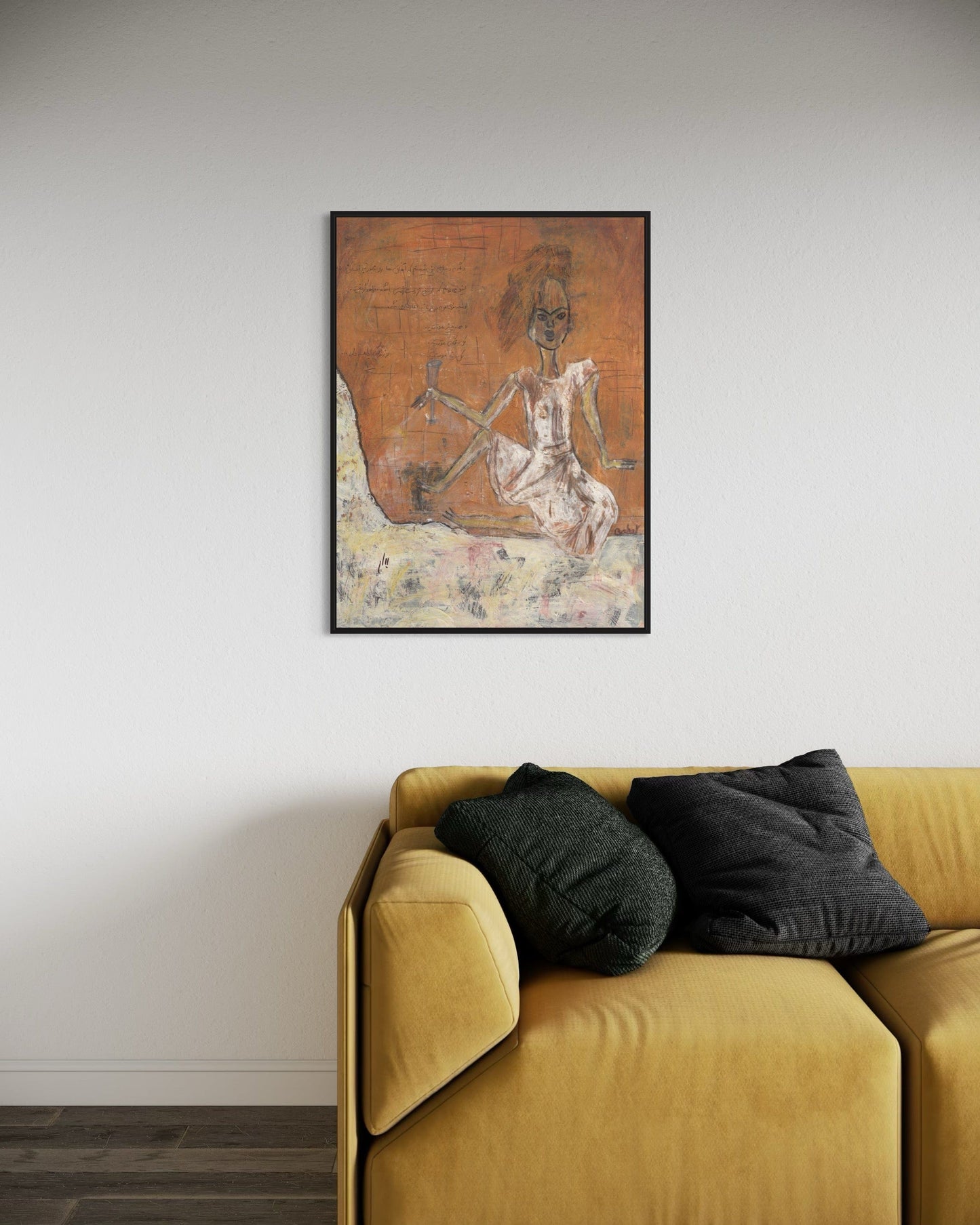 Framed artwork on a wall above a yellow sofa with dark cushions.