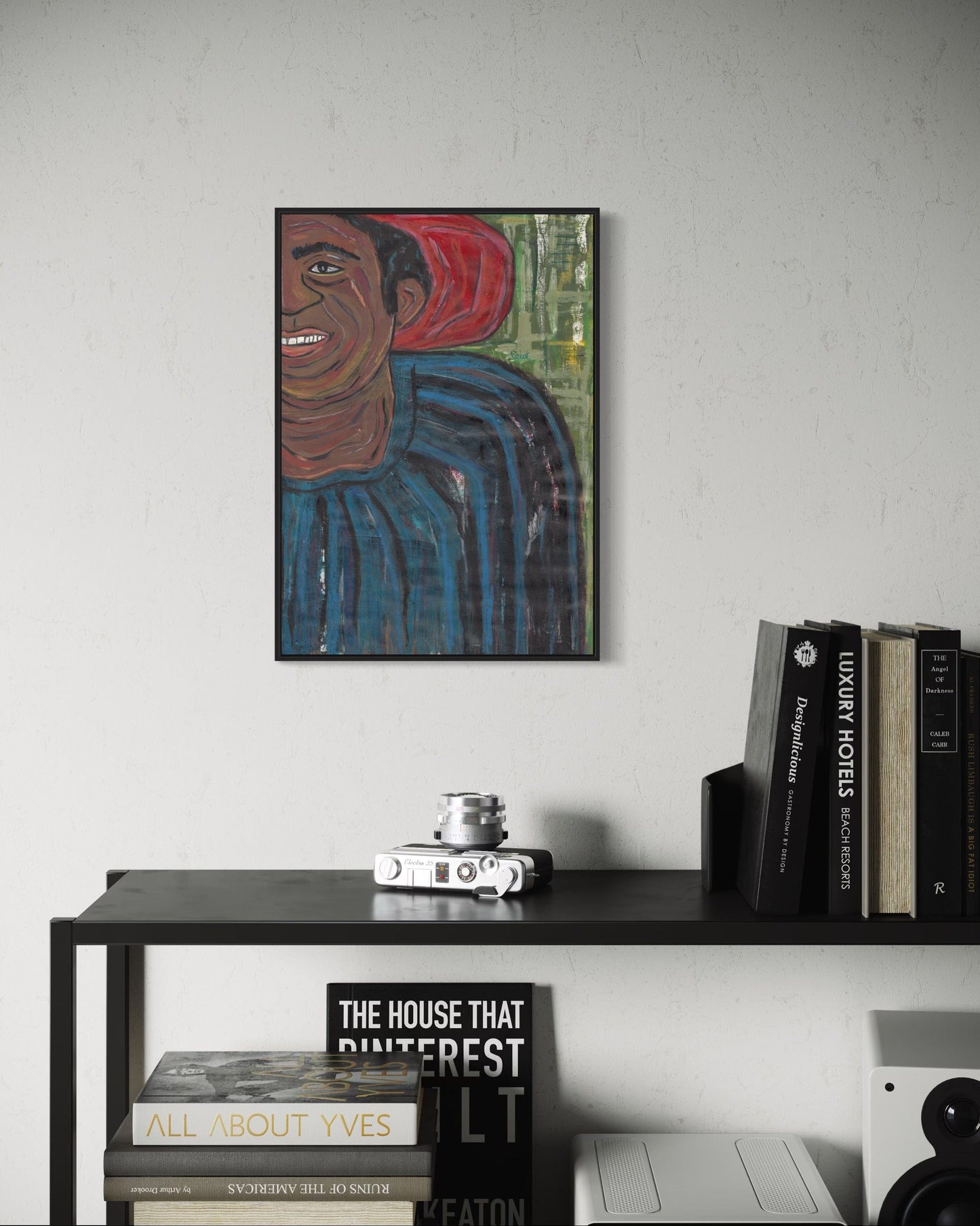 Framed artwork of a person with a red object on a white wall above a shelf with books and decor.
