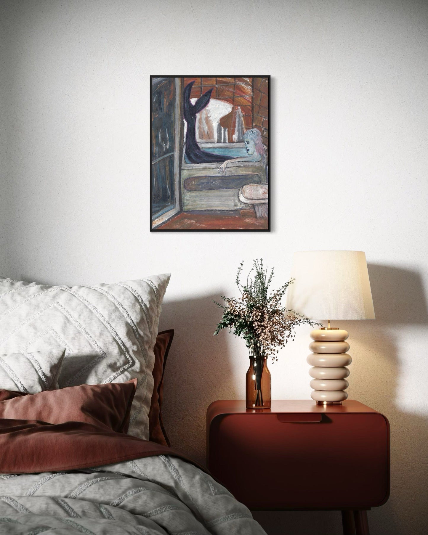 Bedroom with a nightstand, lamp, and decorative items on a neutral wall.