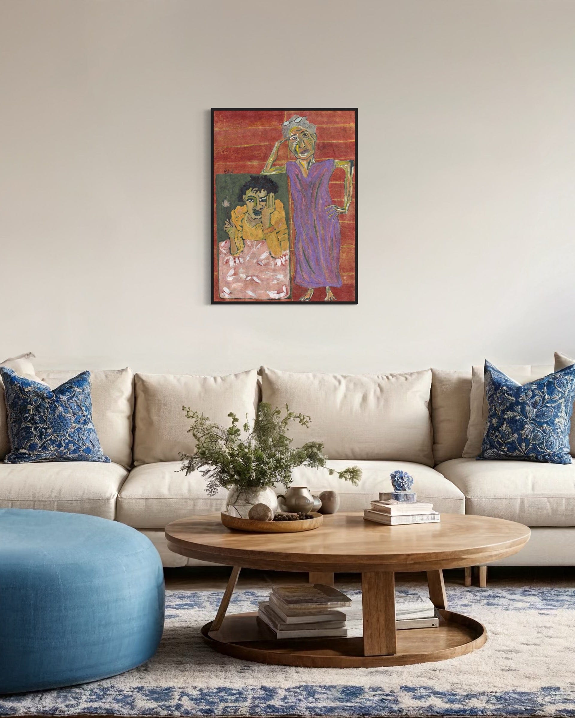 Living room with beige sofa, blue ottoman, wooden coffee table, and colorful wall art.