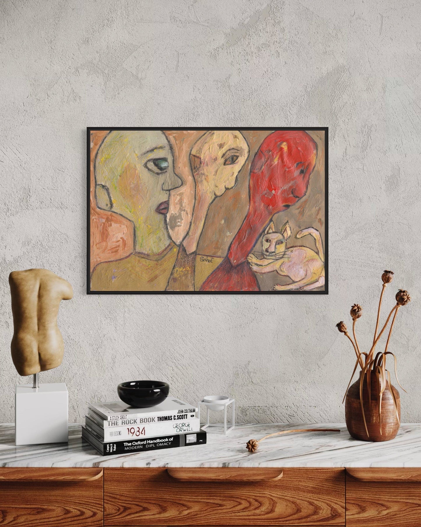Abstract painting of three faces on a wall above a wooden cabinet with decorative items.