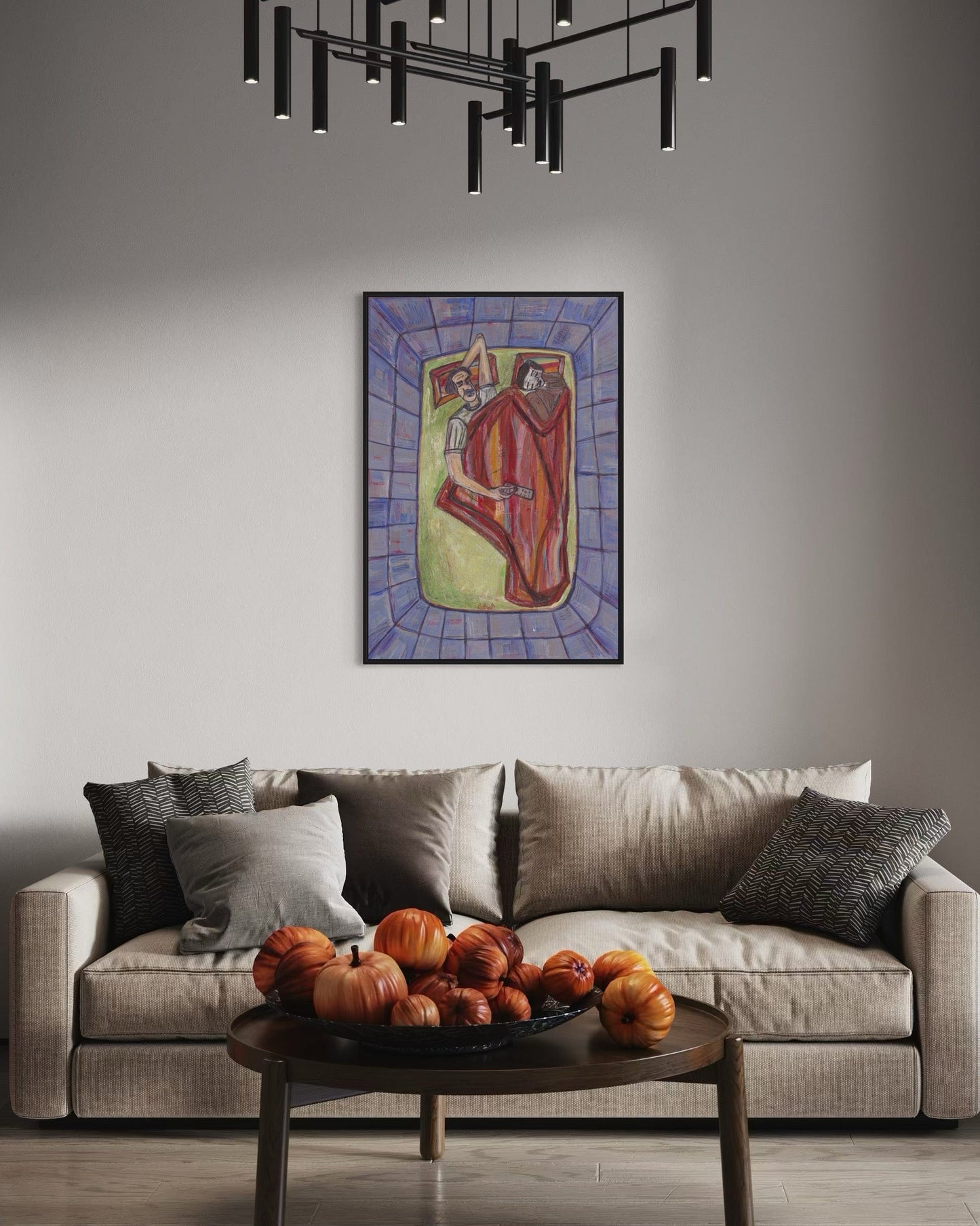 Living room with a beige sofa, decorative pumpkins on a coffee table, and a colorful painting above.