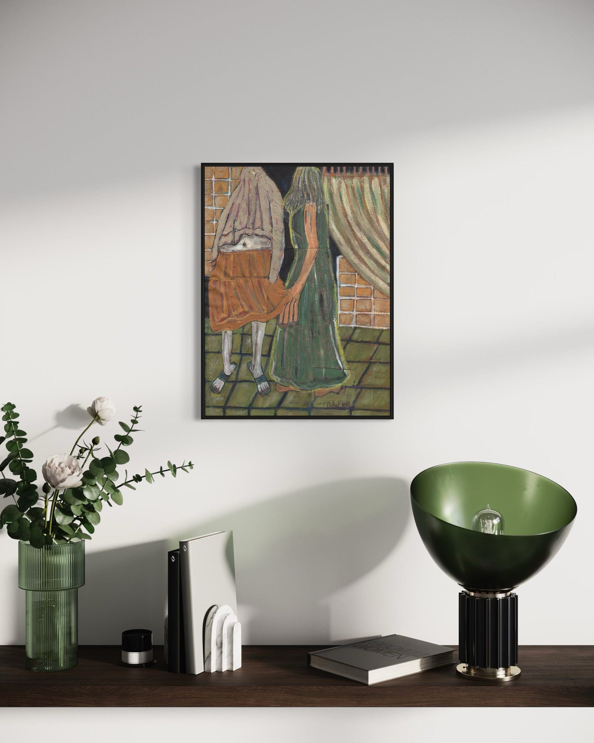 Framed artwork on a wall above a wooden surface with decorative items.