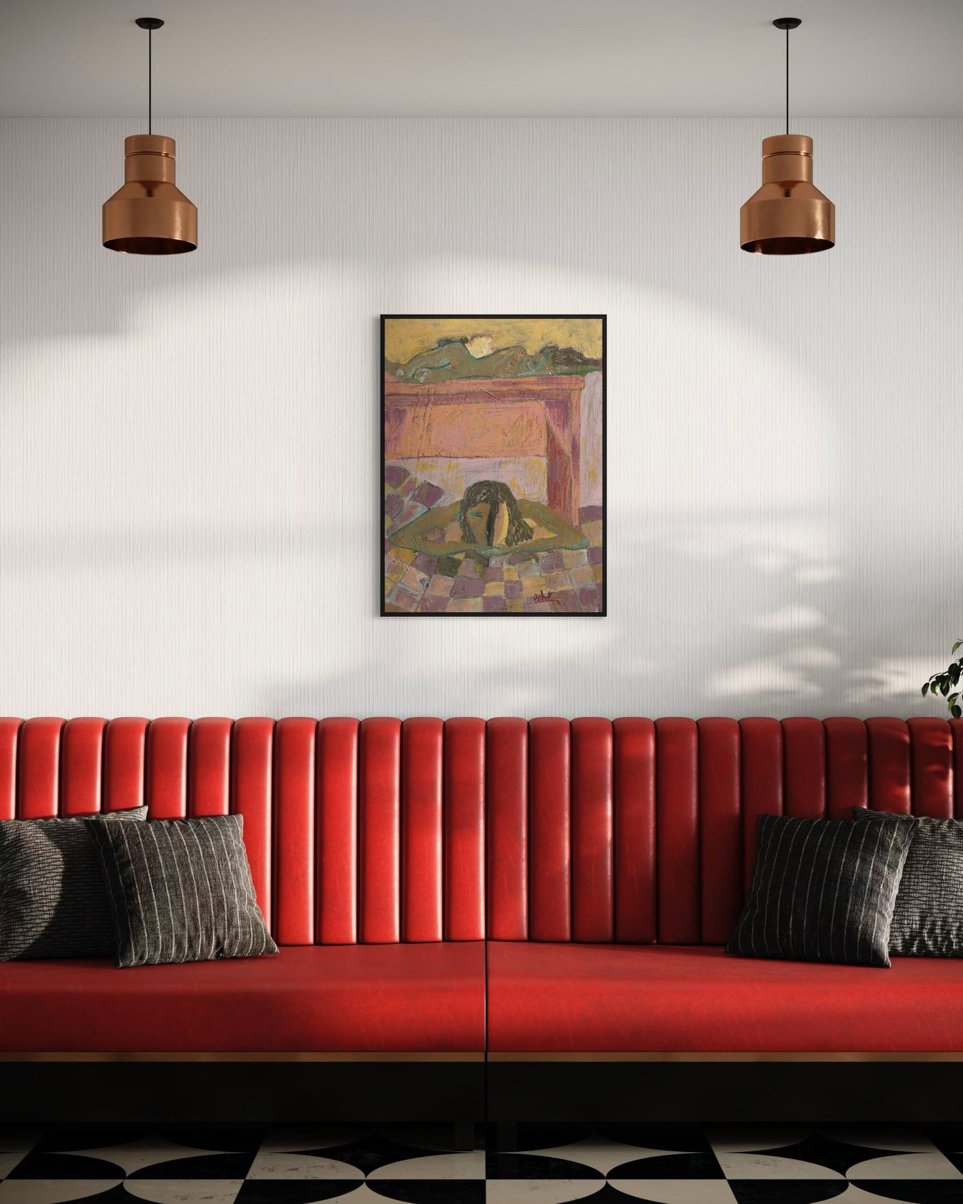 Red sofa with gray cushions in a room with a painting on the wall and two hanging lights.
