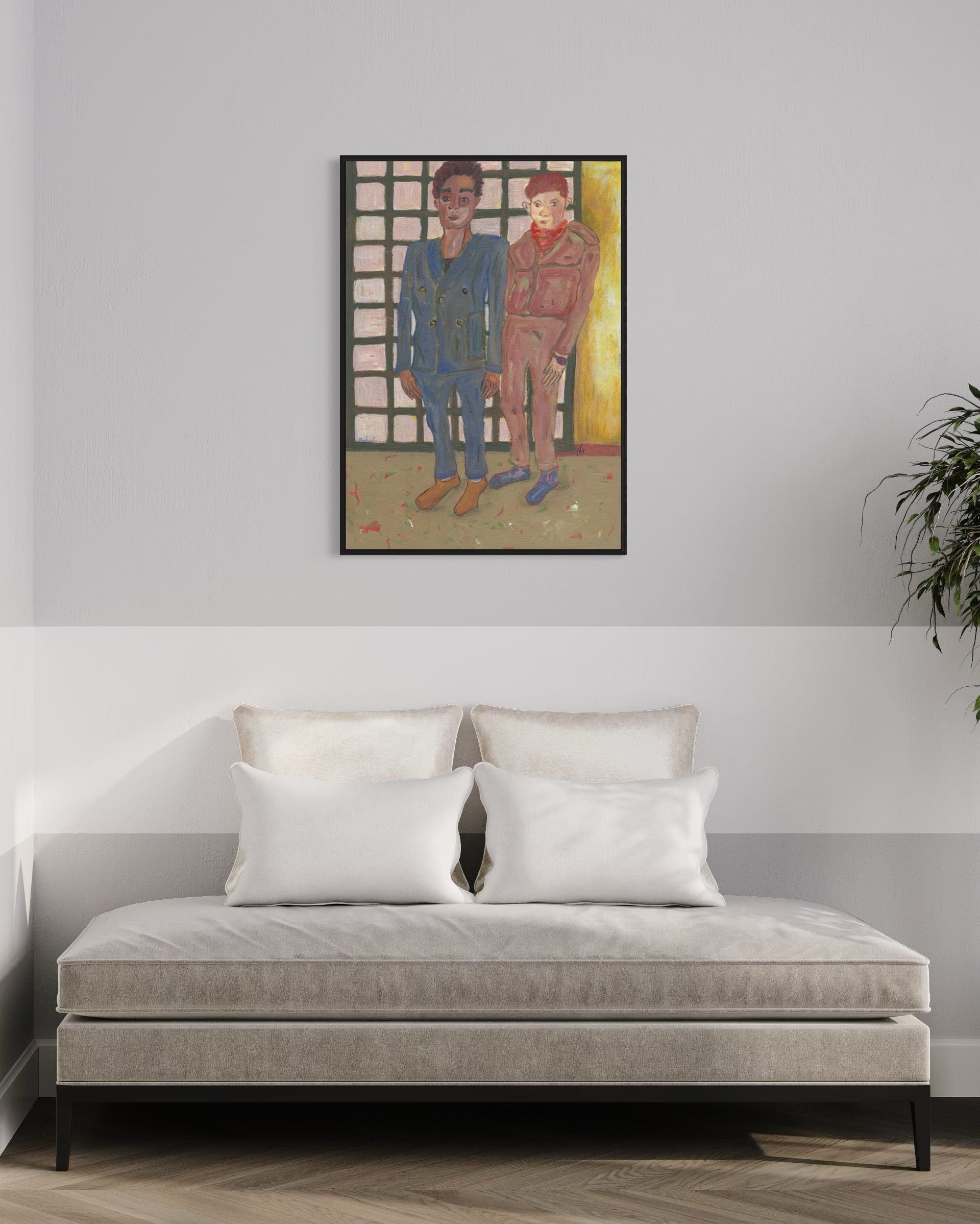 Framed artwork of two people on a wall above a sofa with white cushions.