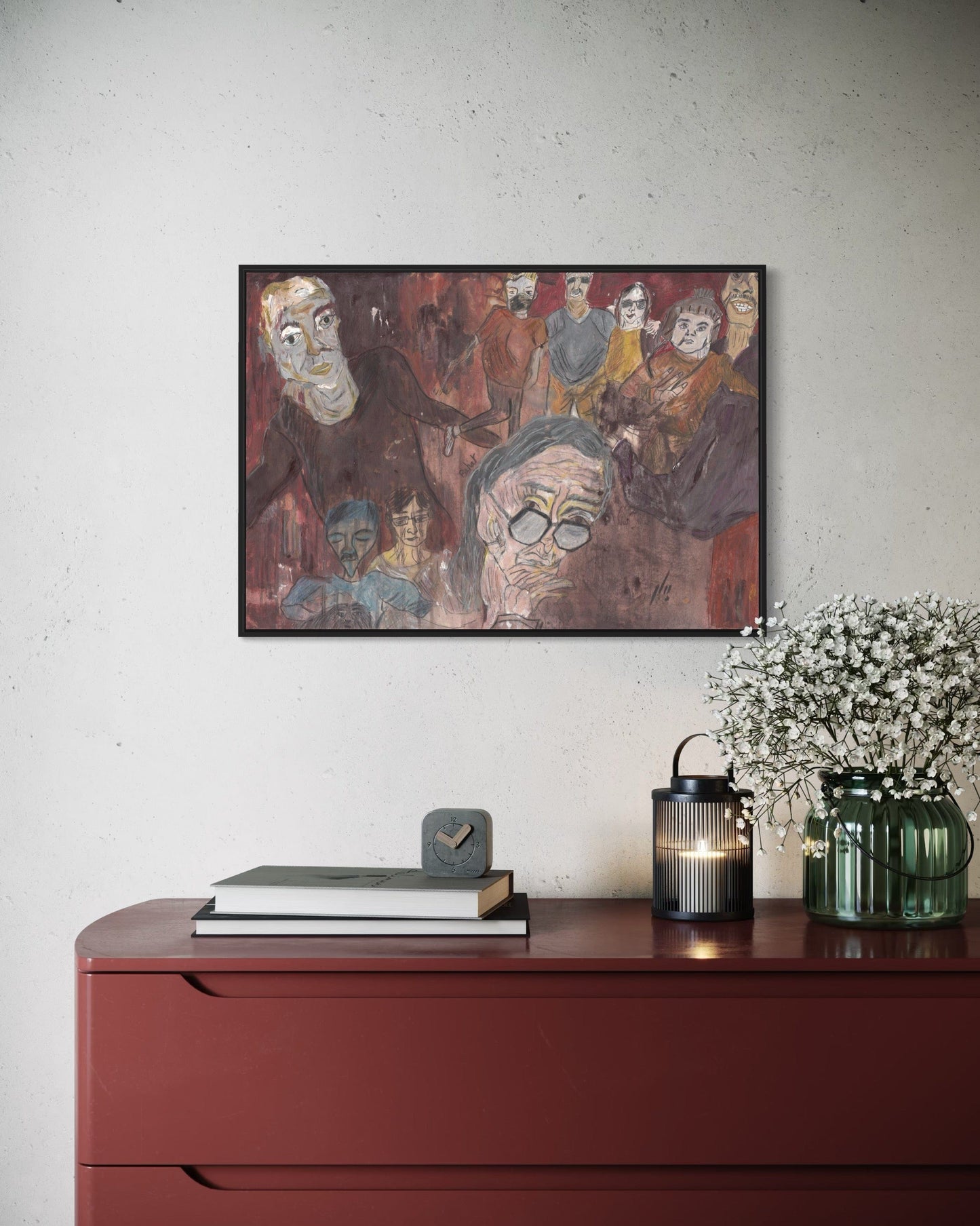 Framed artwork on a wall above a red dresser with decorative items.