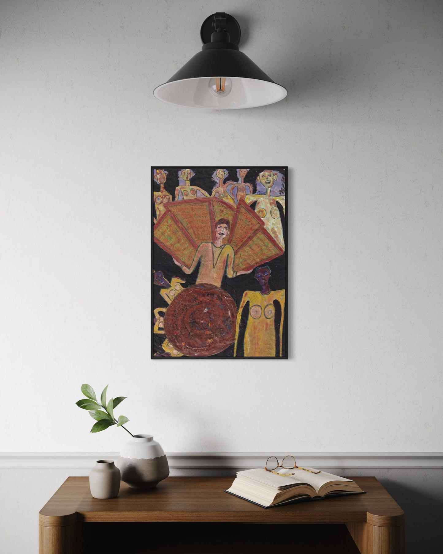 Artistic wall piece on a white wall above a wooden table with decor items.