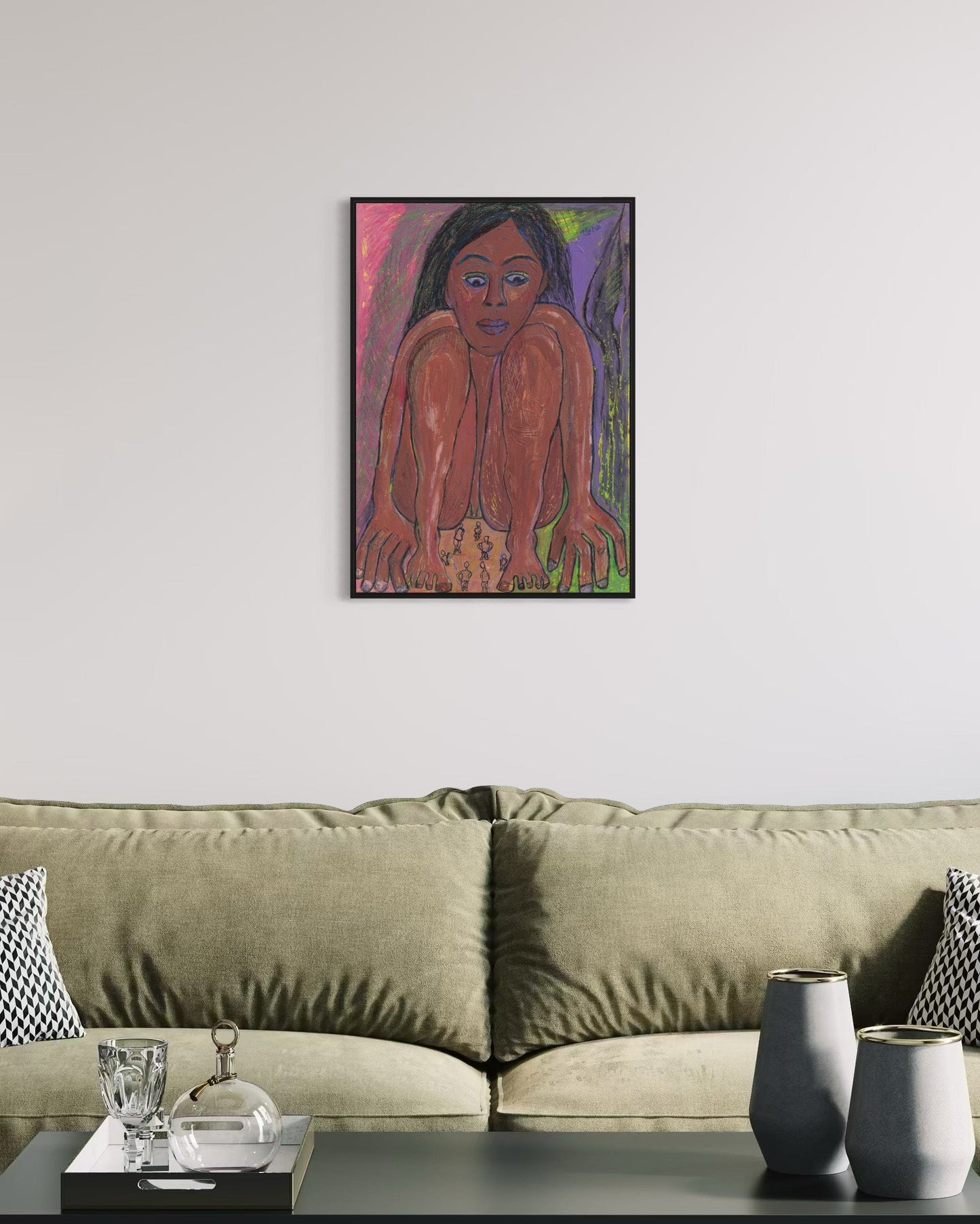 Framed artwork of a person on a wall above a beige sofa with decorative items.