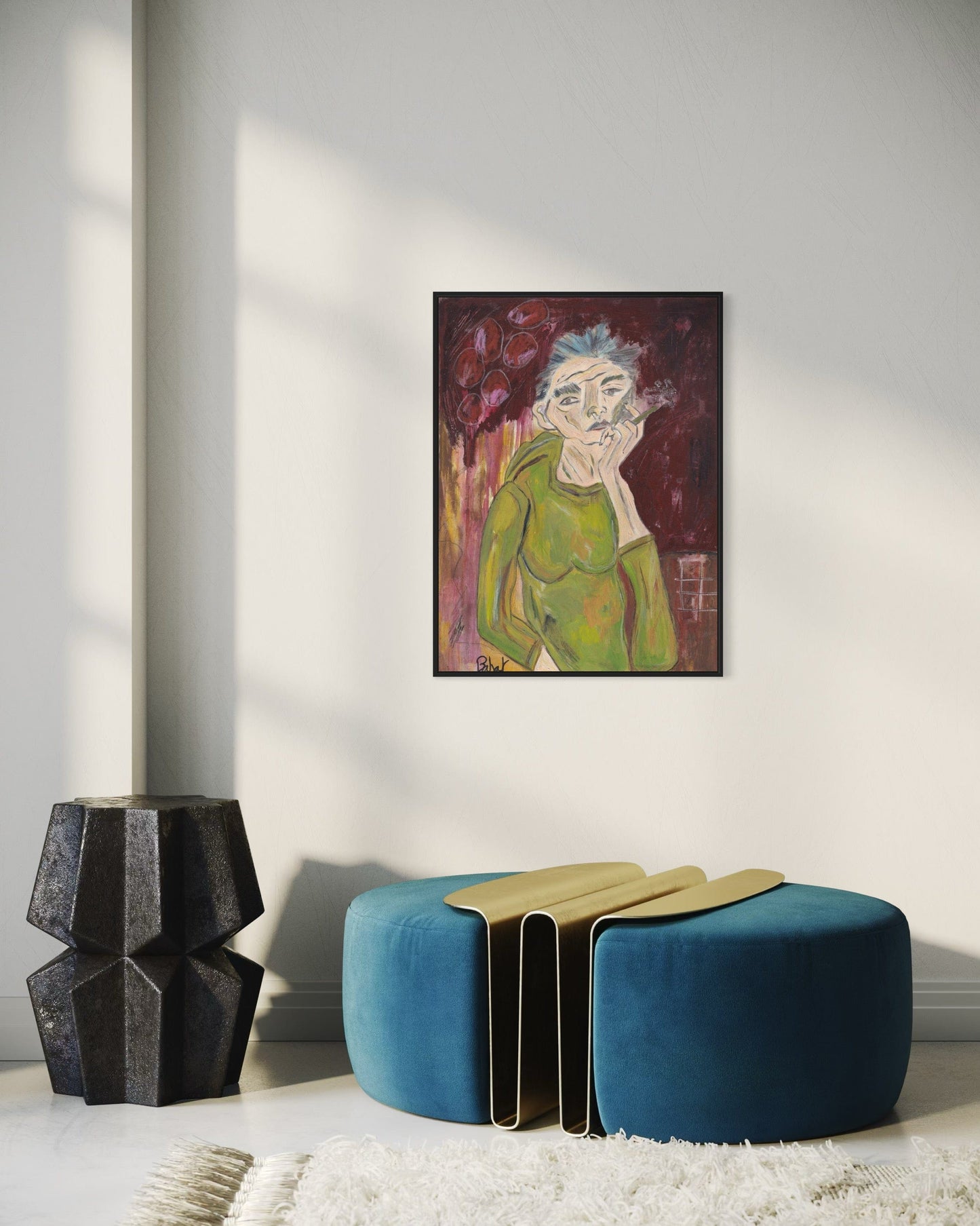 Modern interior with a blue ottoman, black vase, and framed artwork on the wall.
