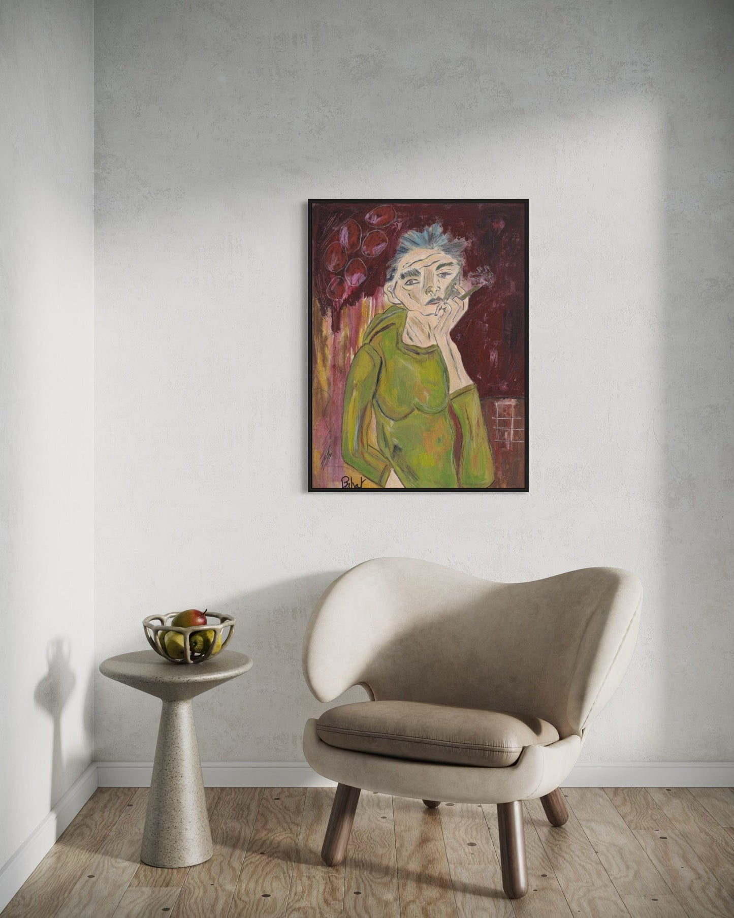 Framed artwork of a stylized portrait on a wall above a beige chair and small table.