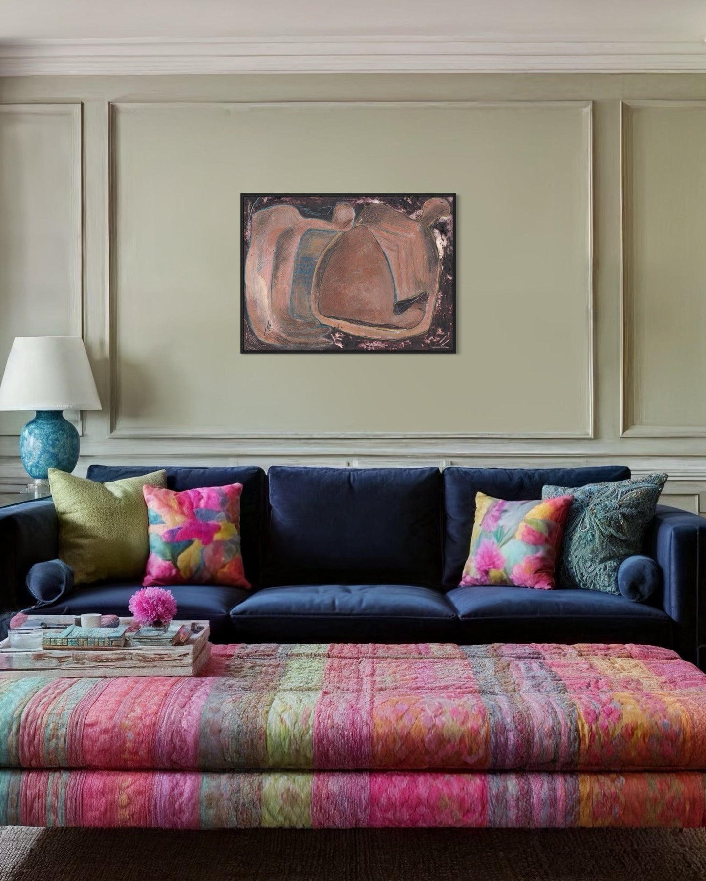 Living room with a navy blue sofa, colorful pillows, and a patterned ottoman.