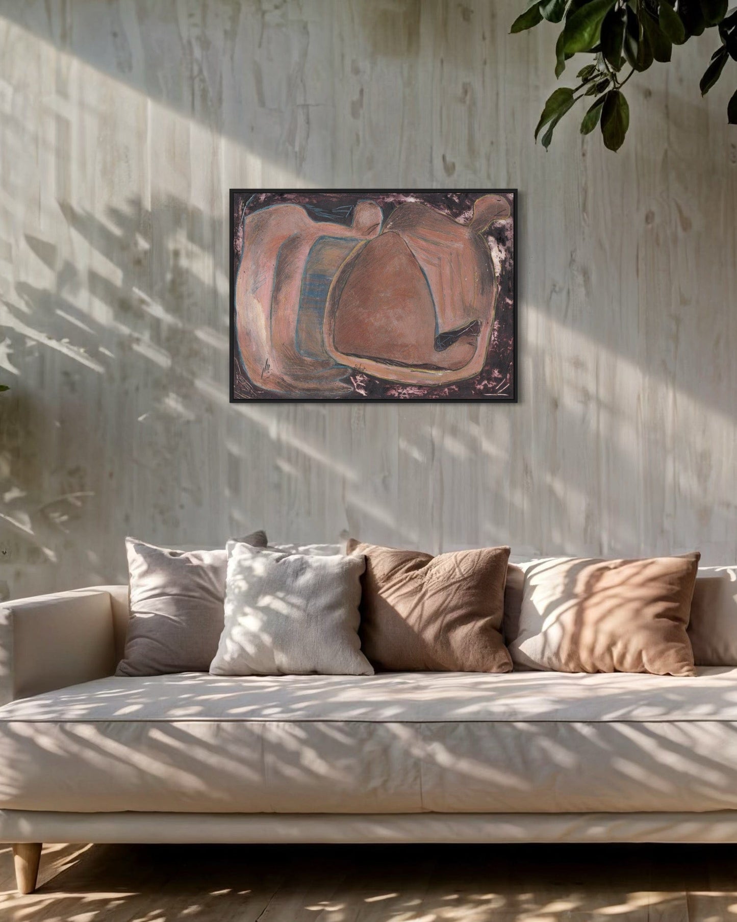 Beige sofa with patterned cushions in a room with a textured wall and abstract painting.