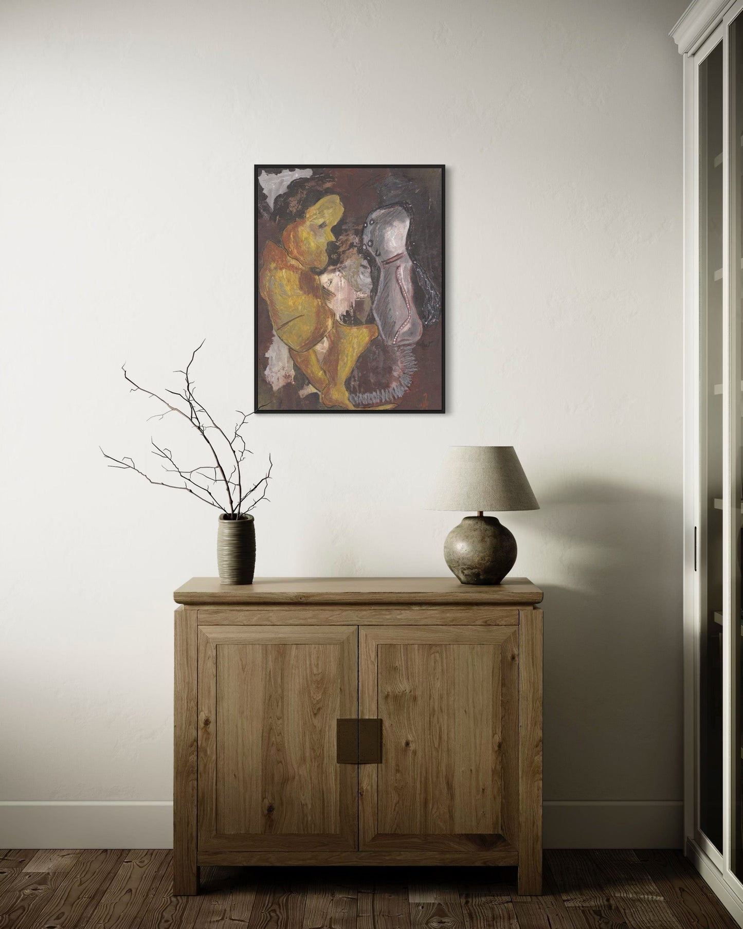 Wooden cabinet with a lamp and decorative item against a wall with a framed painting.