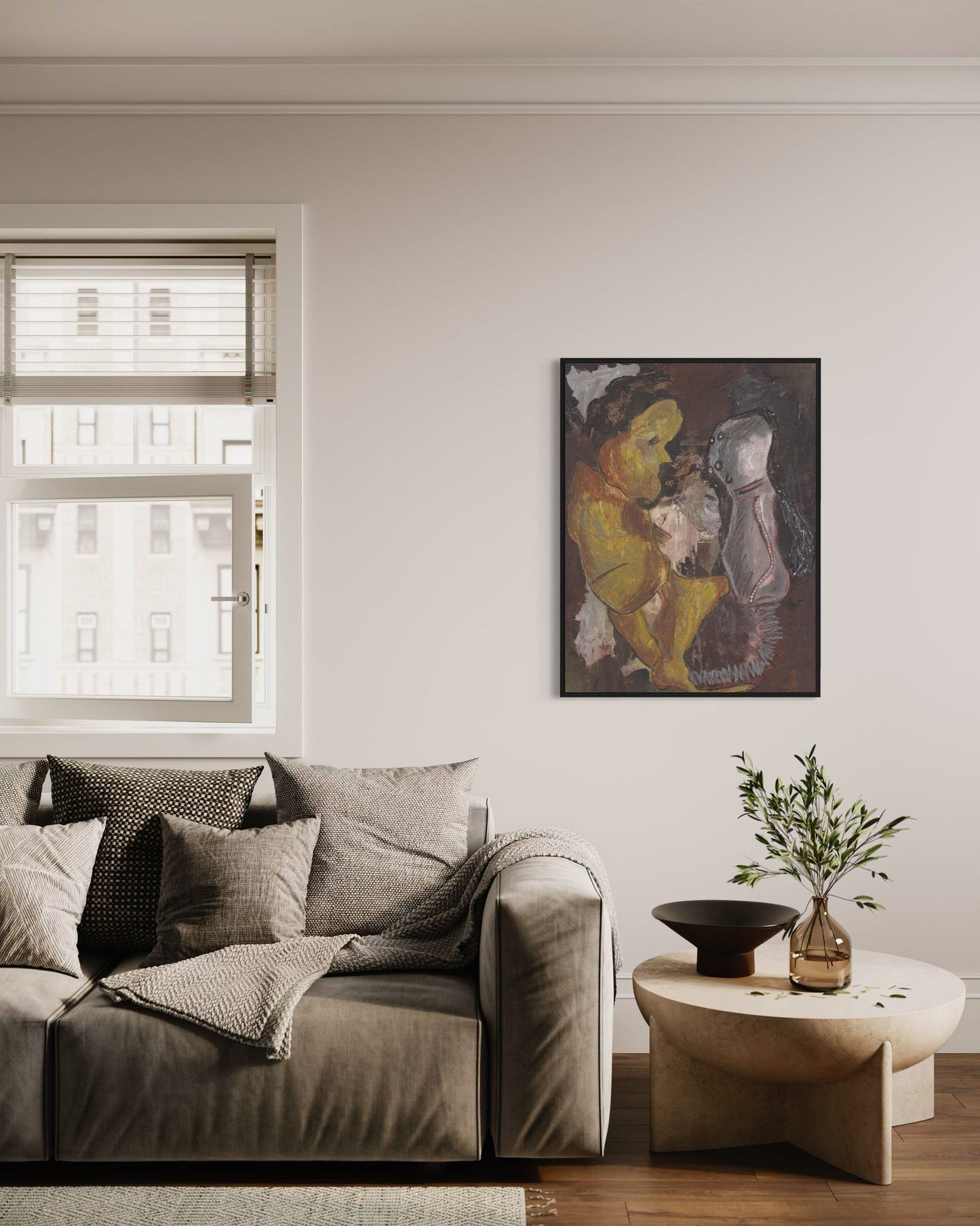 Living room with a gray sofa, round coffee table, and wall art.