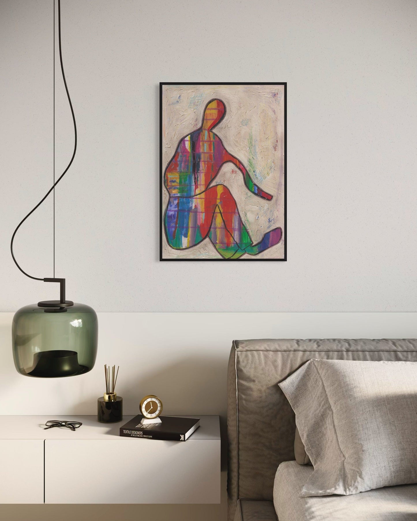 Modern living room with a colorful abstract painting on the wall, a gray sofa, and a green pendant light.