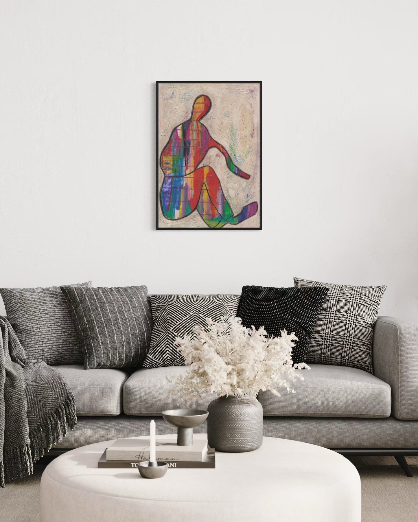 Living room with a gray sofa, colorful abstract art, and decorative items.