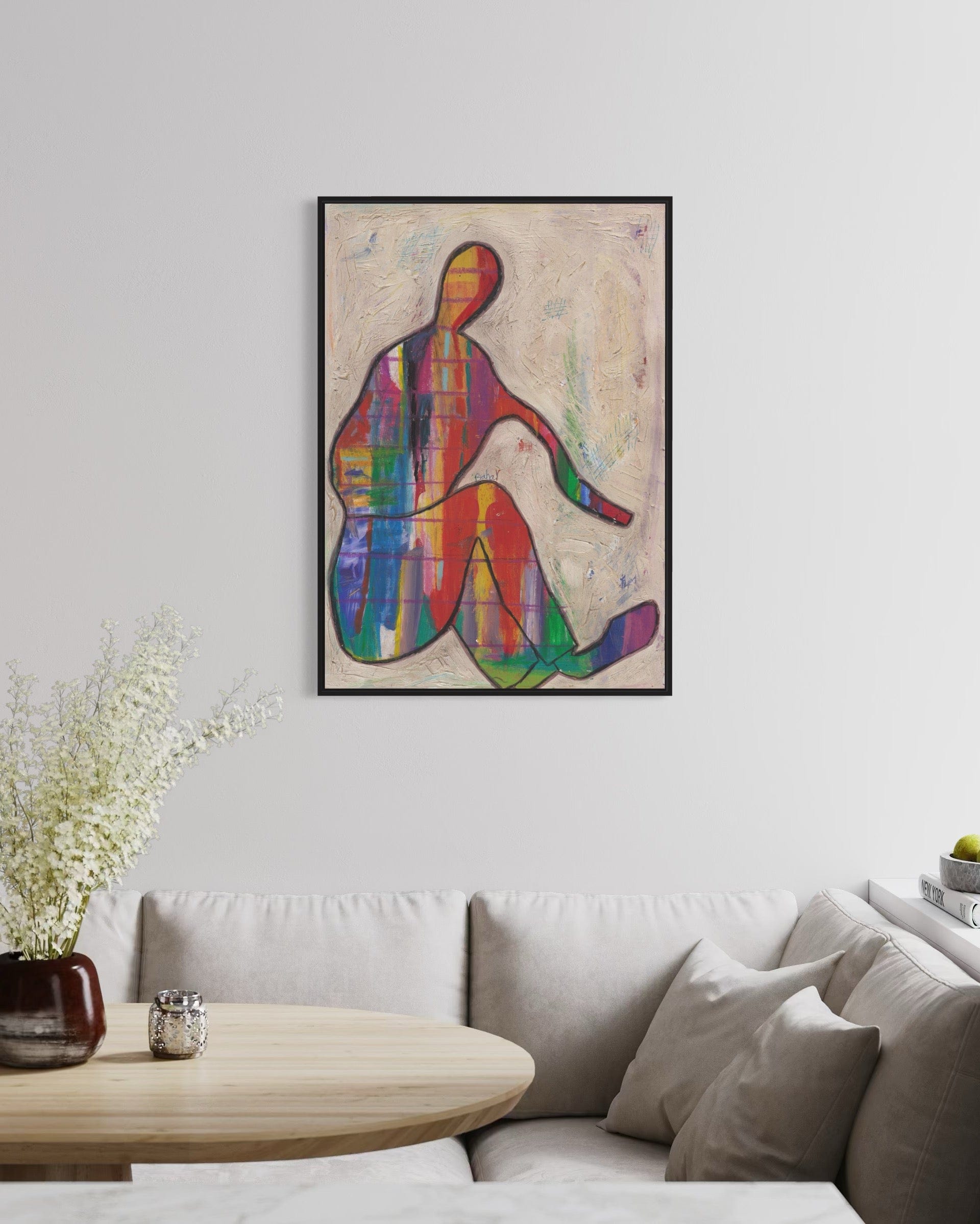 Colorful abstract art piece on a wall above a sofa in a living room.