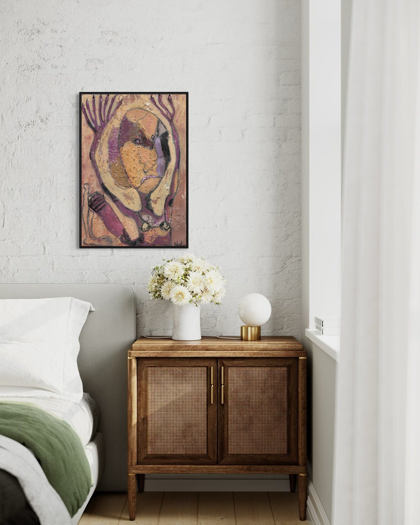 Decorative wall art above a wooden cabinet with a vase of flowers in a bedroom setting.
