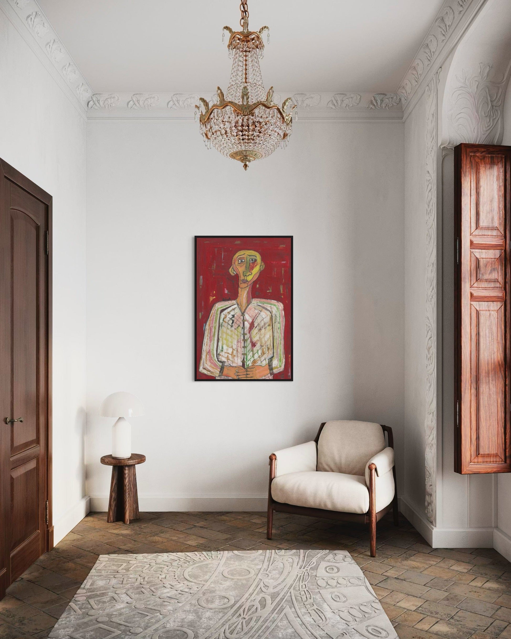 Elegant interior with a chandelier, armchair, and wall art in a room with wooden floors and white walls.