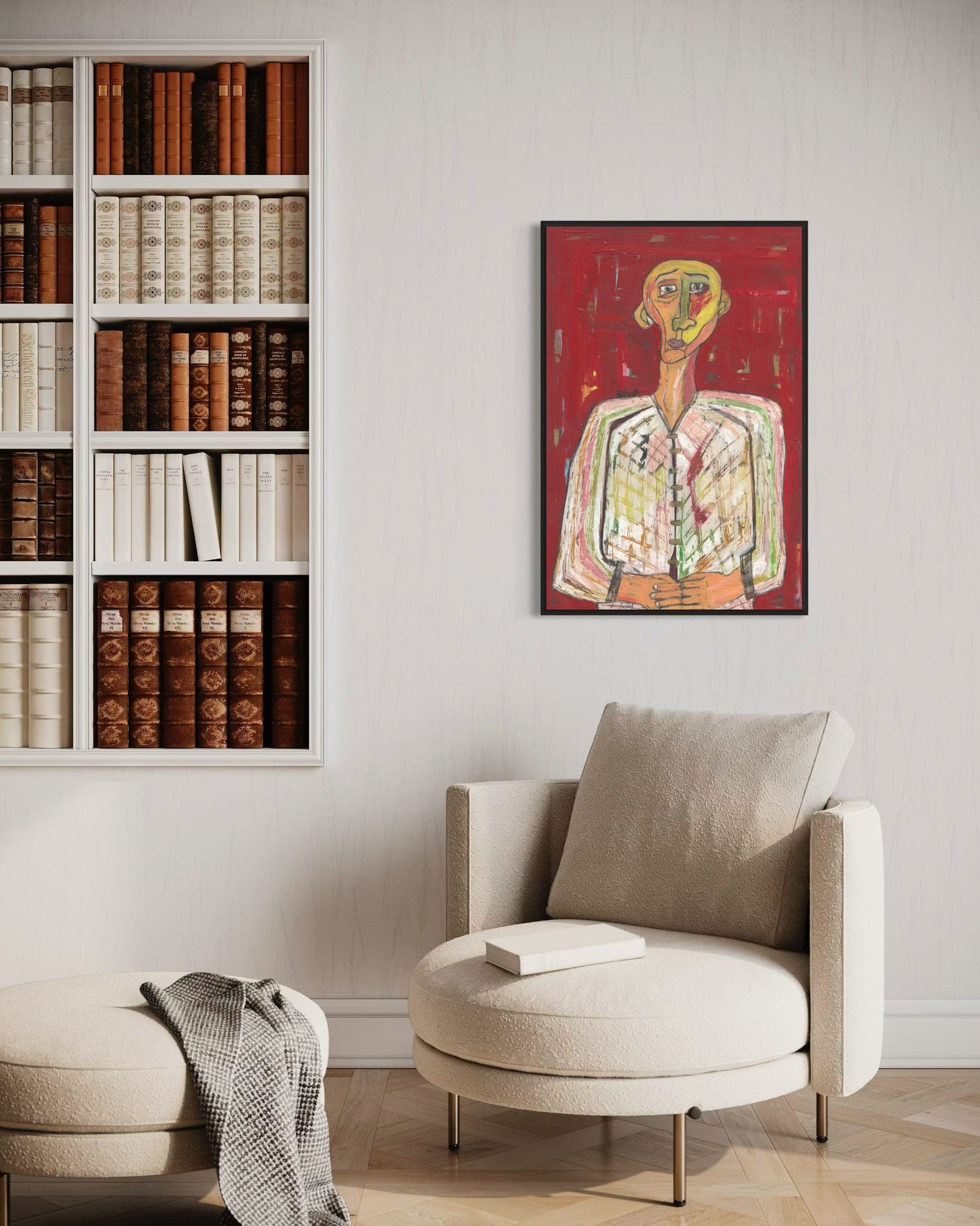 Modern living room with a bookshelf, armchair, and framed artwork on the wall.