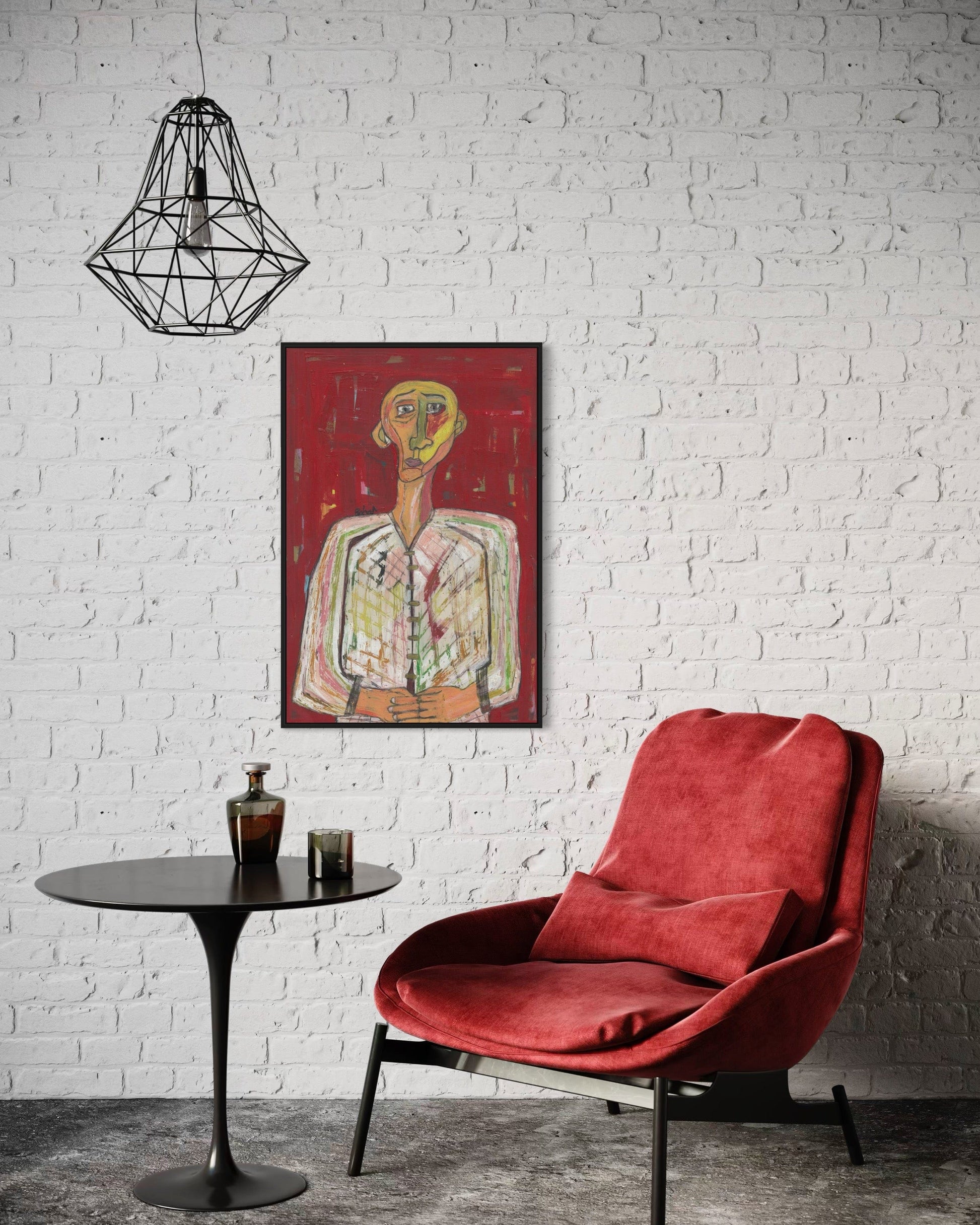 Red chair and table in front of a white brick wall with a framed abstract painting.