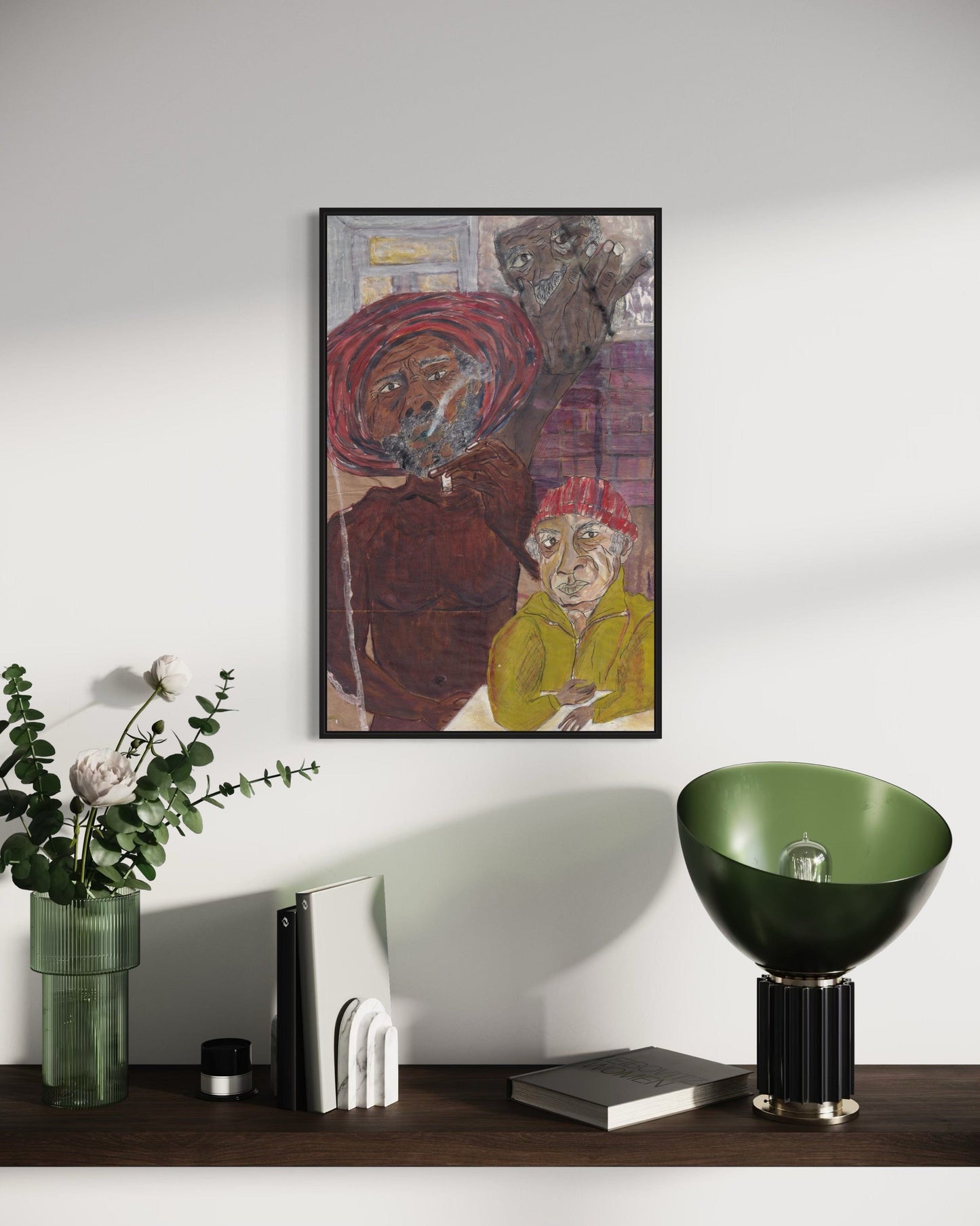 Framed artwork on a wall above a wooden surface with decorative items.