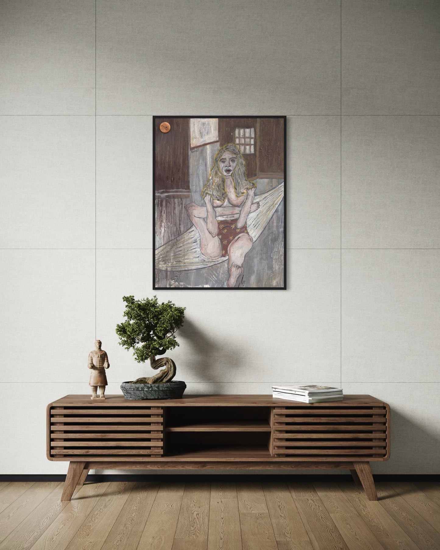 Wooden console table with decorative items against a light gray wall with a framed artwork.