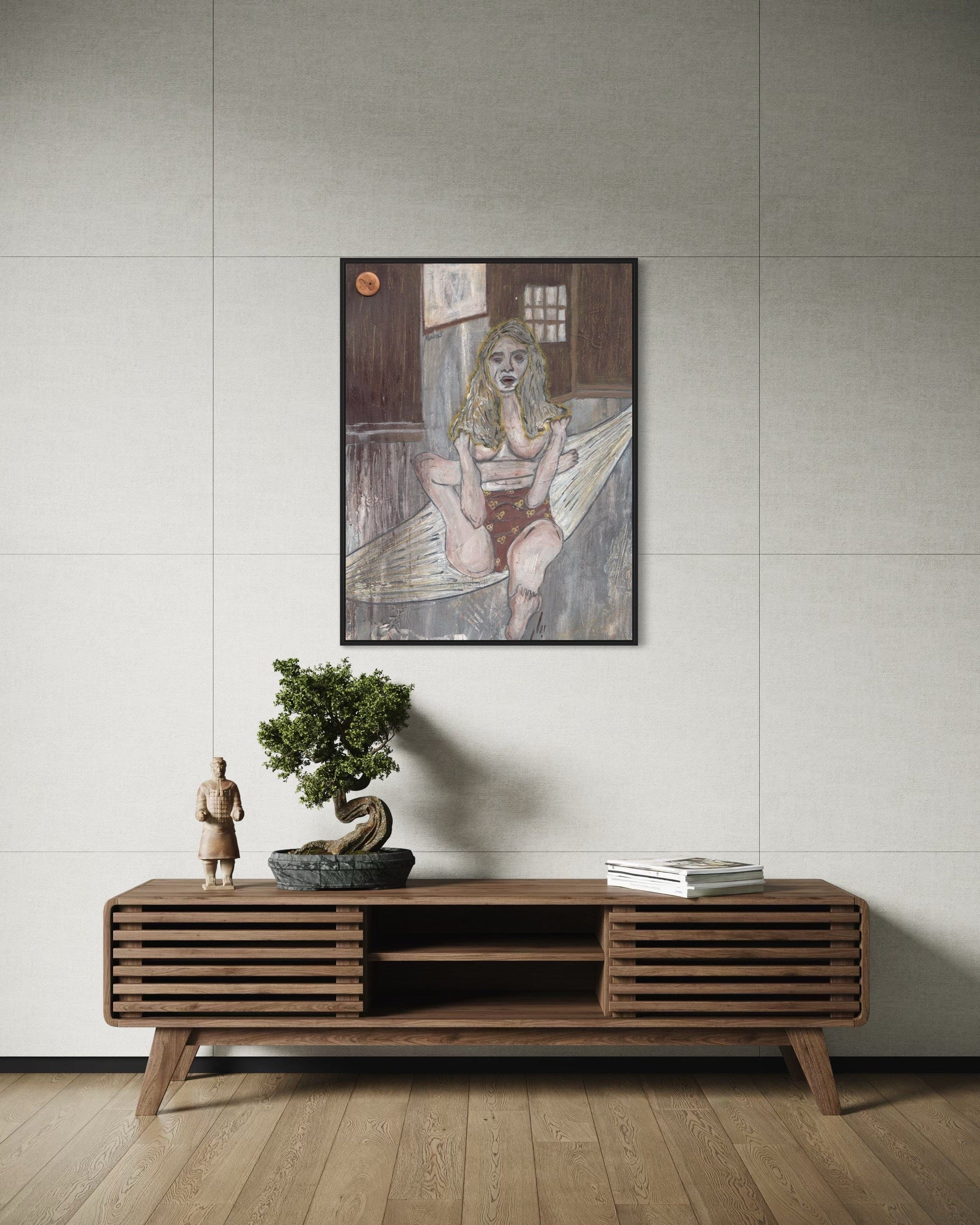 Wooden console table with decorative items against a light gray wall with a framed artwork.