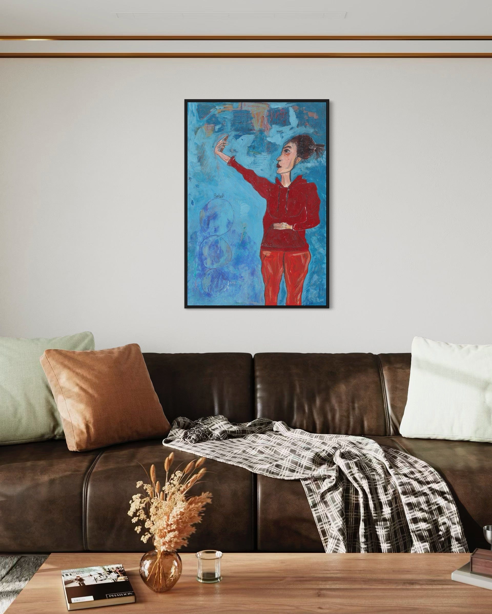 Living room with a brown leather sofa, wooden coffee table, and a colorful abstract painting of a woman on the wall.