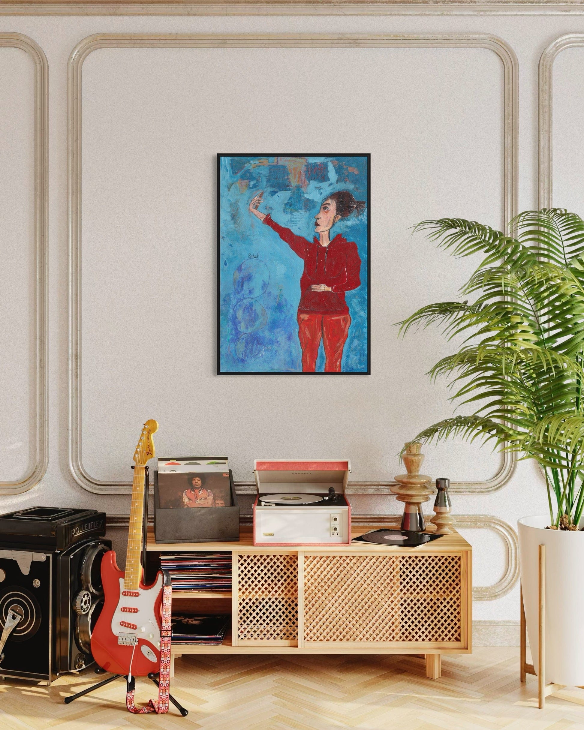 Living room with a wooden cabinet, guitar, and framed artwork on a wall.