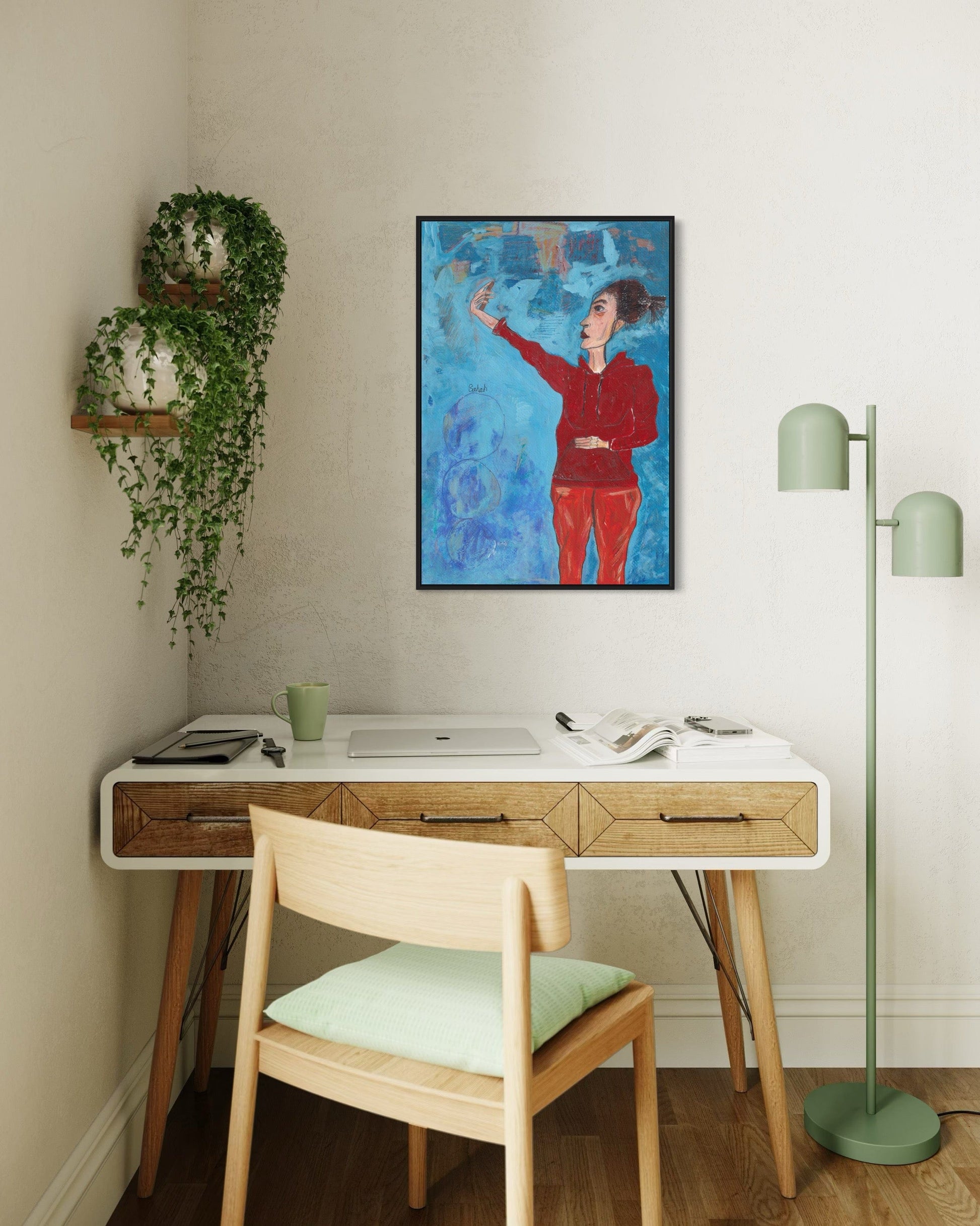 Home office with a desk, chair, lamp, and wall art.