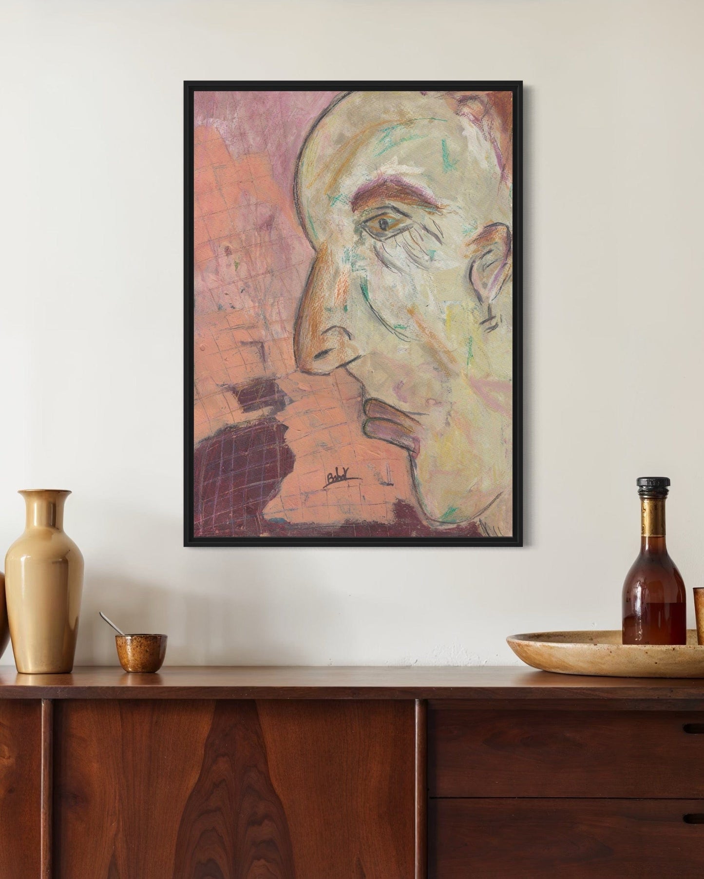 Framed abstract artwork on a wall above a wooden console table with decorative items.