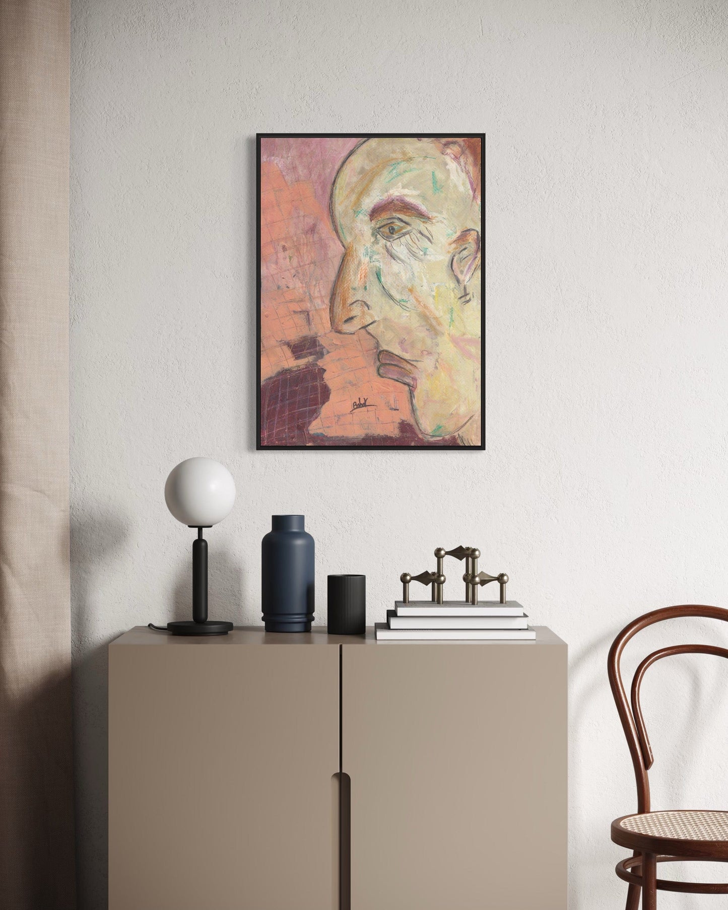 Framed artwork on a wall above a cabinet with decorative items.