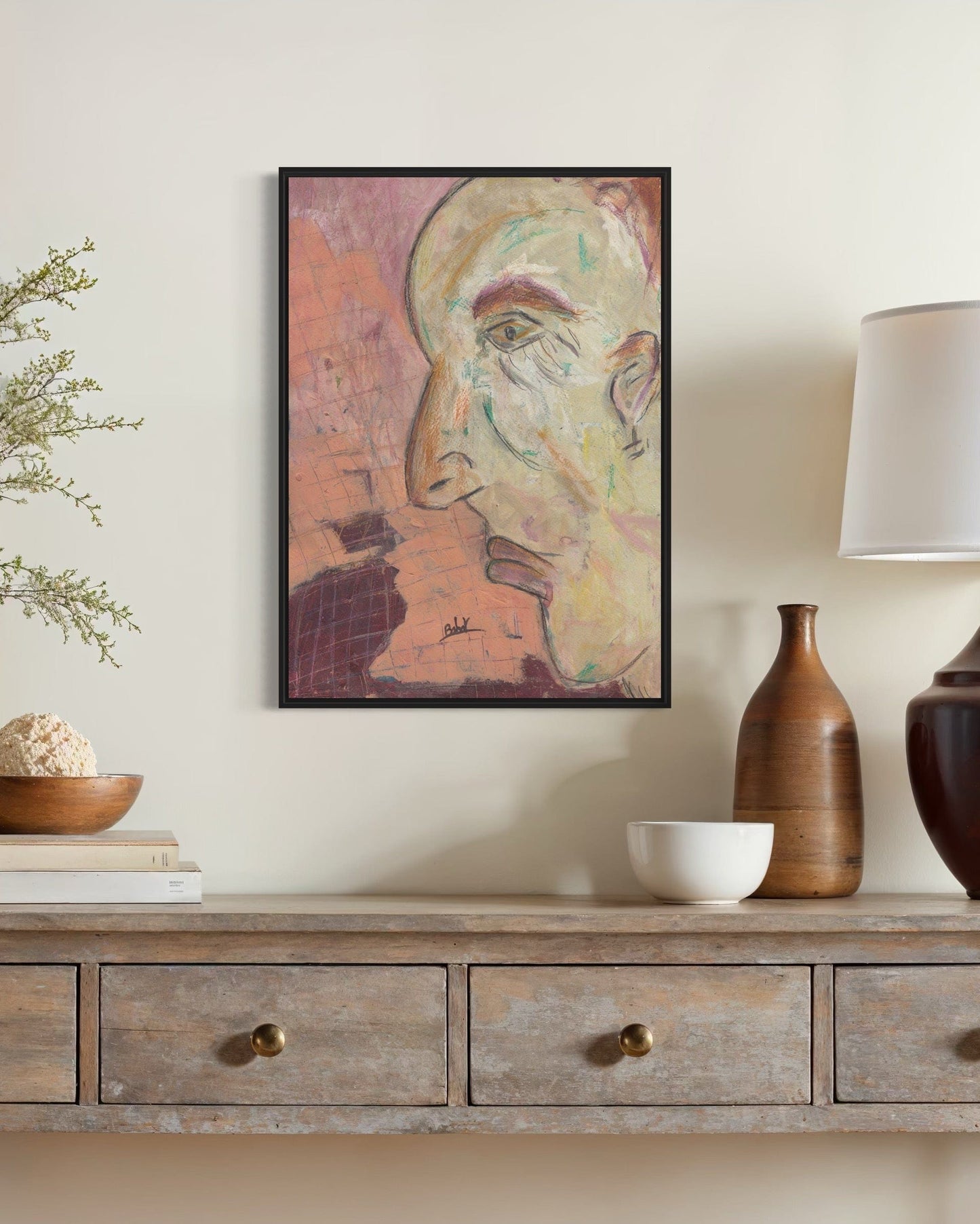 Framed artwork on a wall above a wooden console table with decorative items.