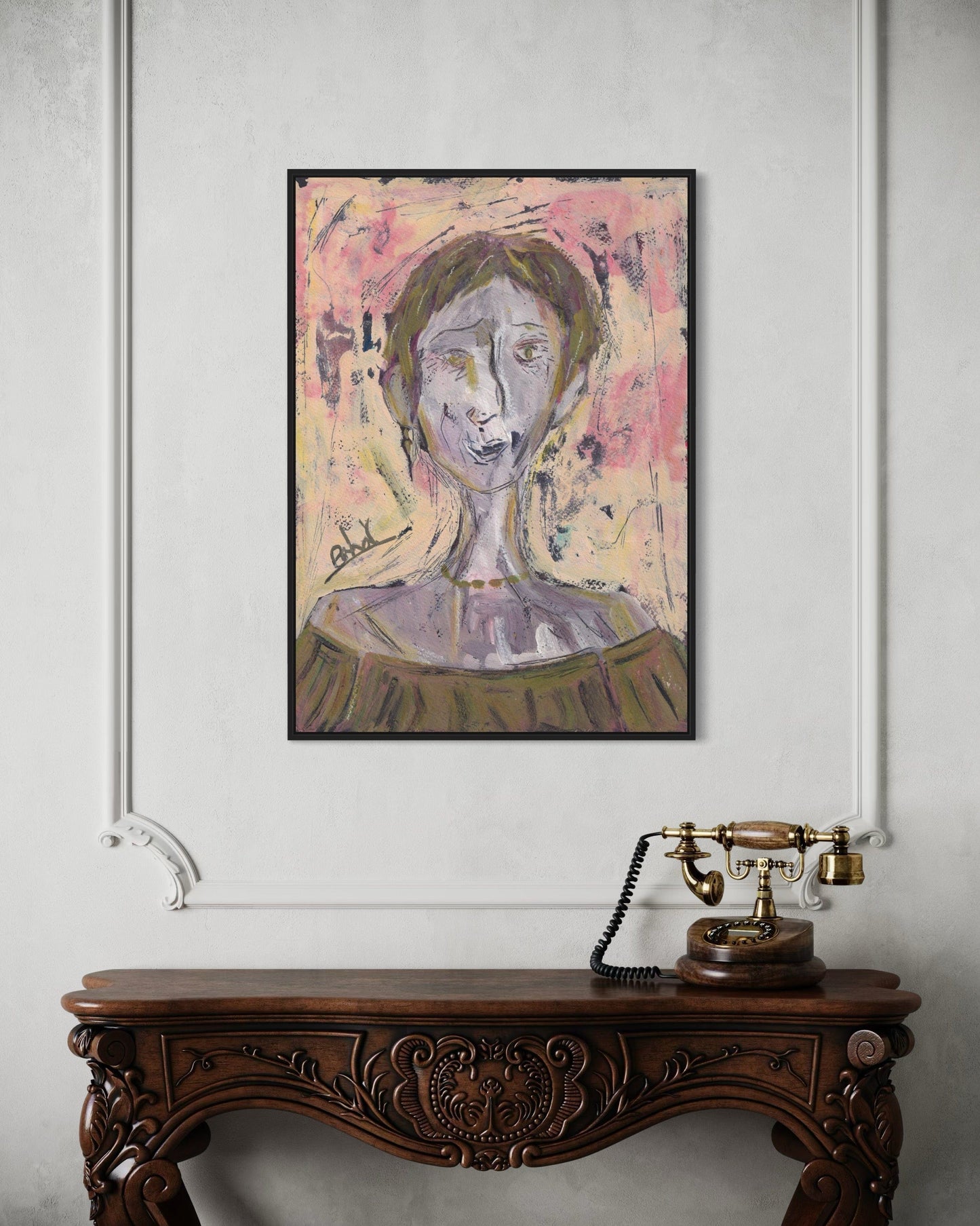 Framed abstract portrait above a wooden console table with a vintage telephone.