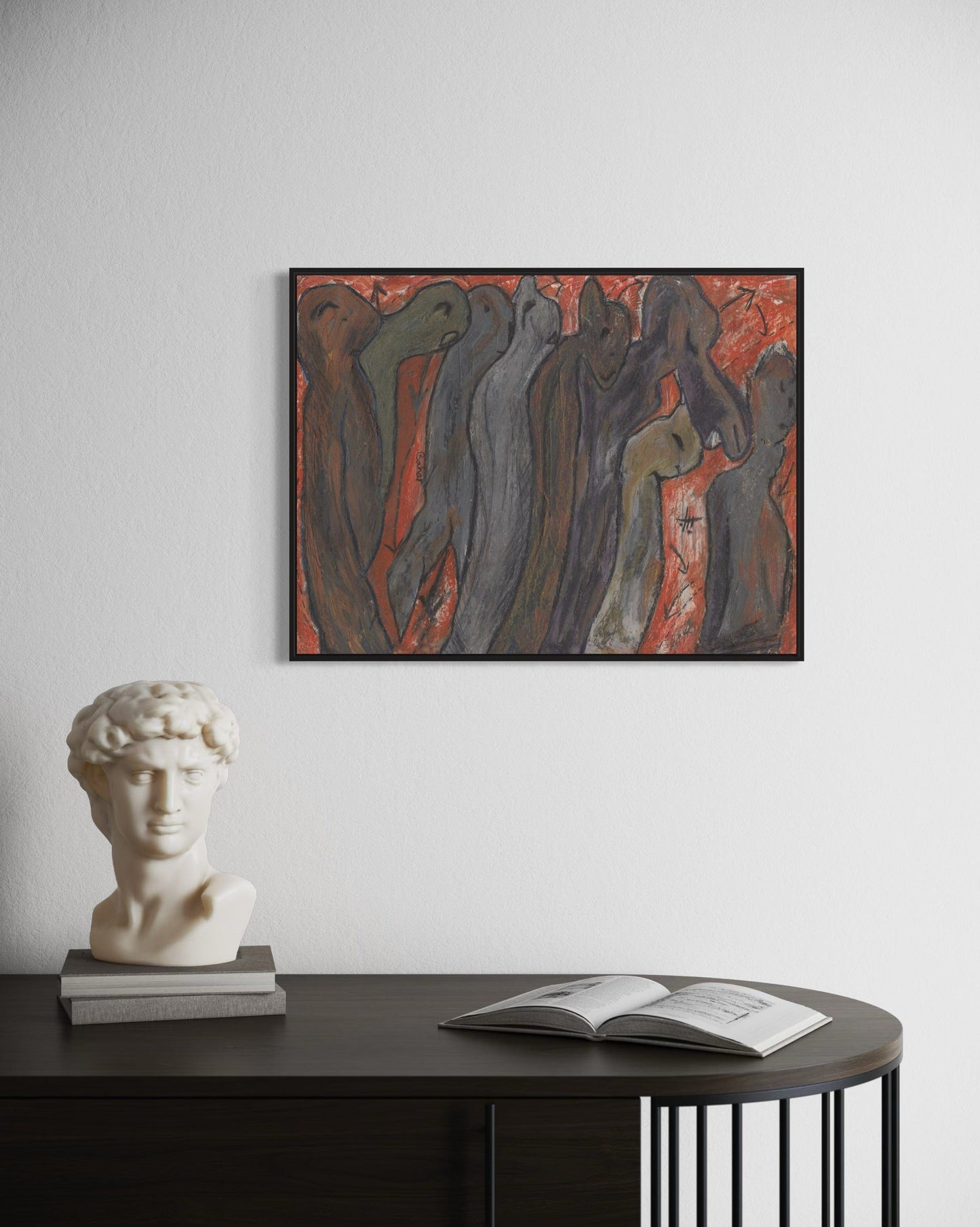 Framed abstract painting on a wall above a table with a bust and open book.