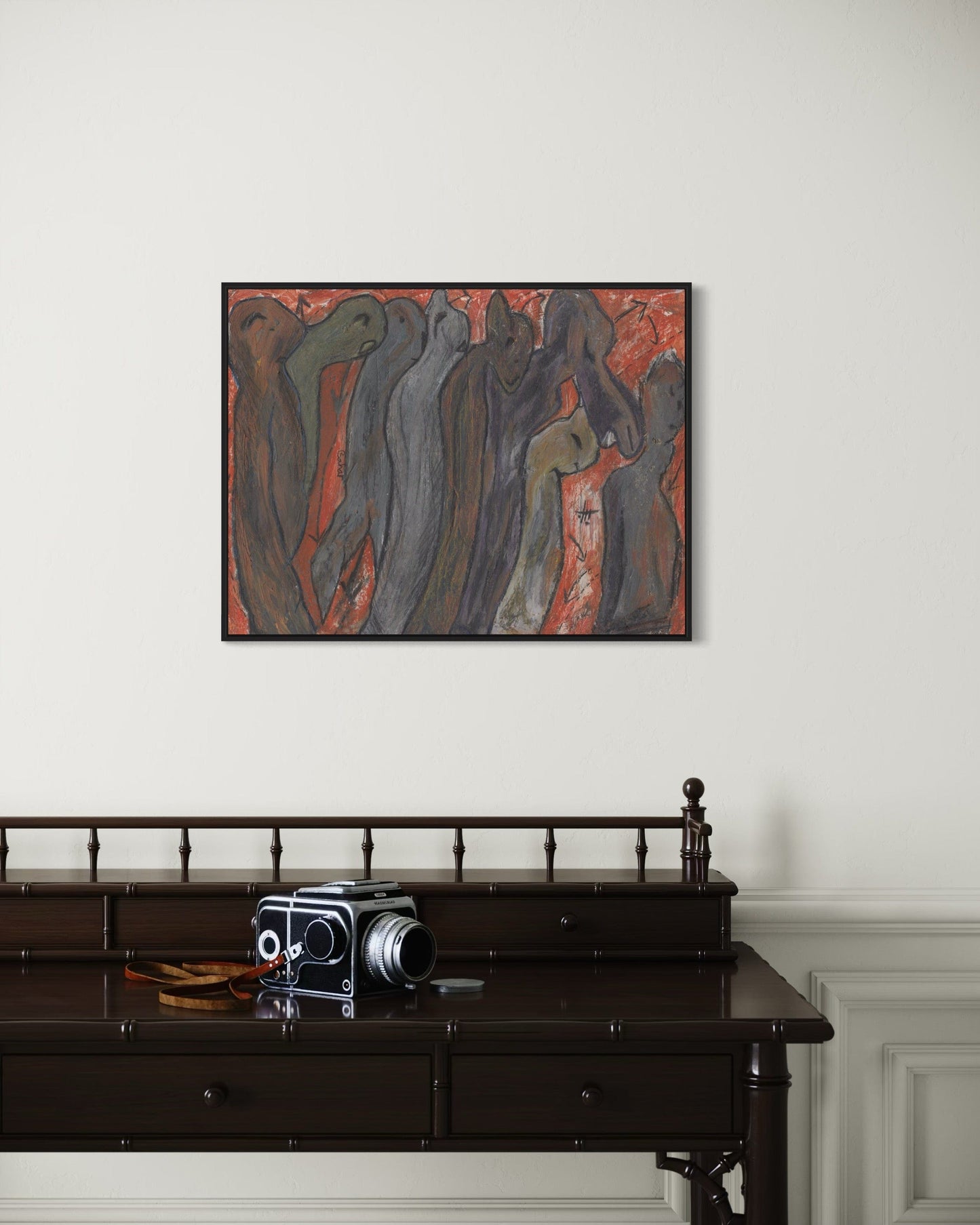 Abstract painting on a wall above a dark wooden desk with an old camera.