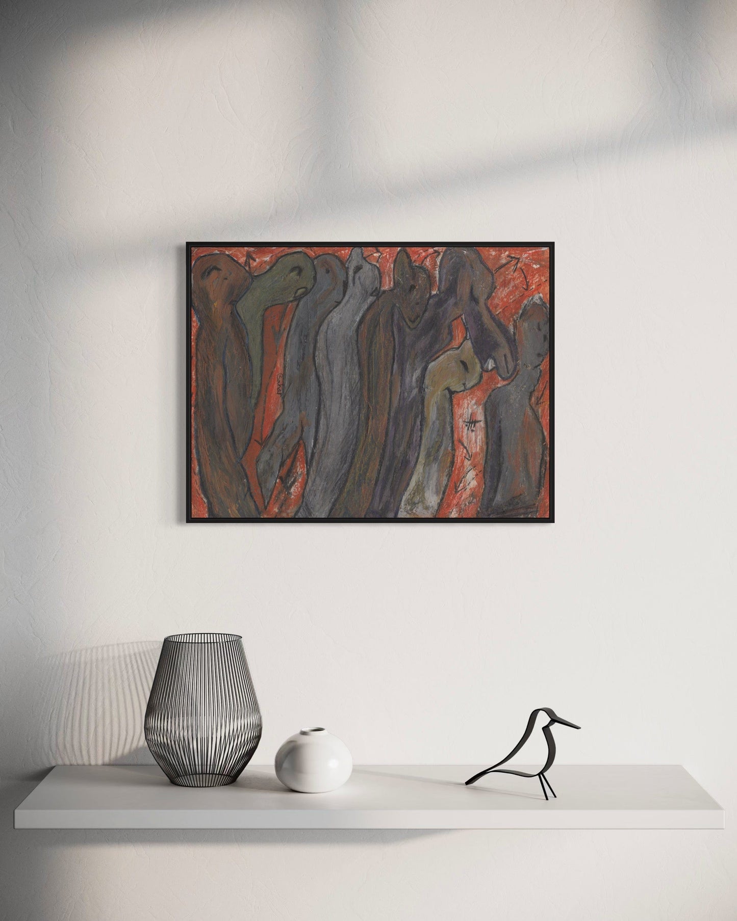 Framed abstract artwork on a wall above a white shelf with decorative items.