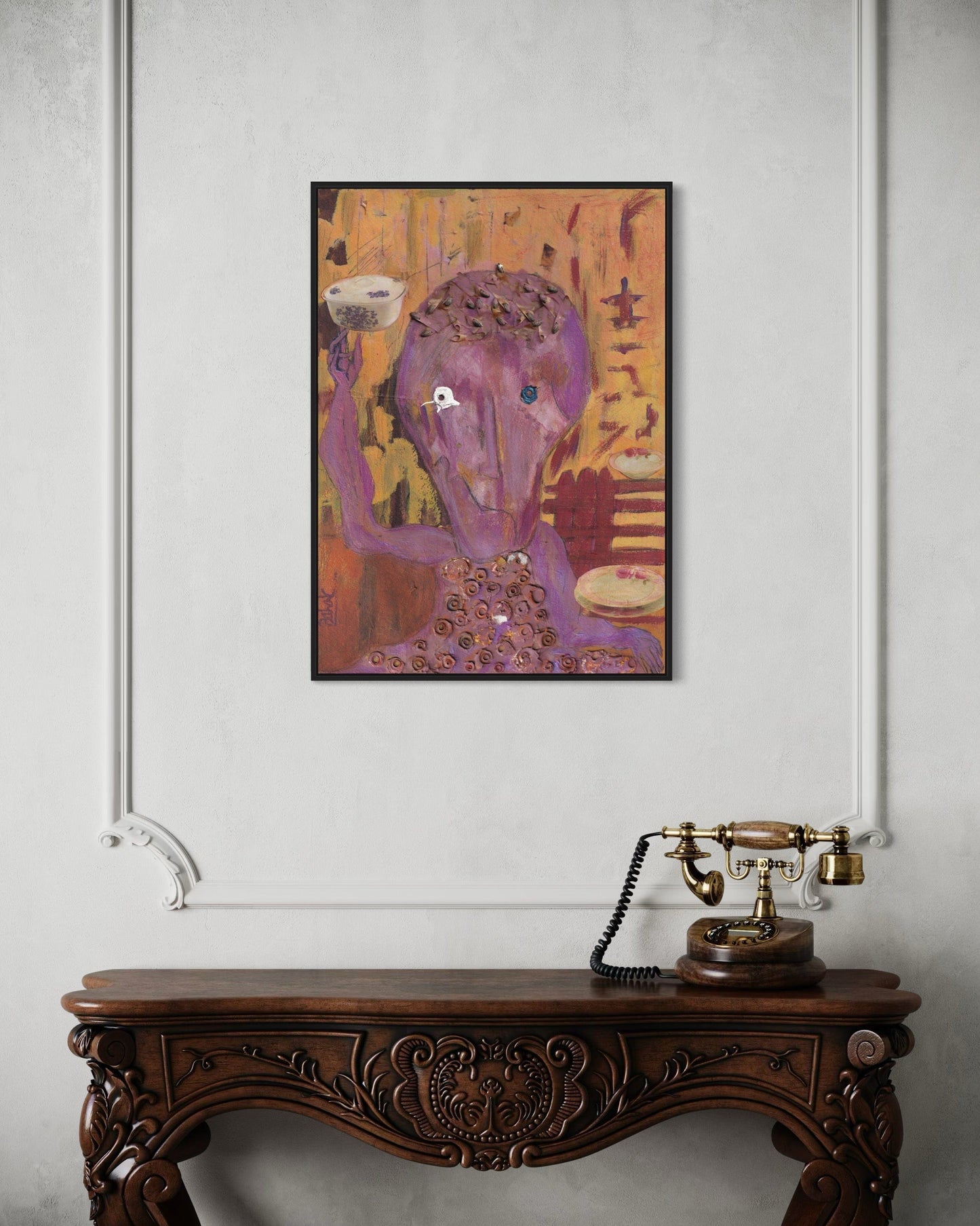 Framed abstract painting on a wall above an ornate wooden console table with a vintage telephone.