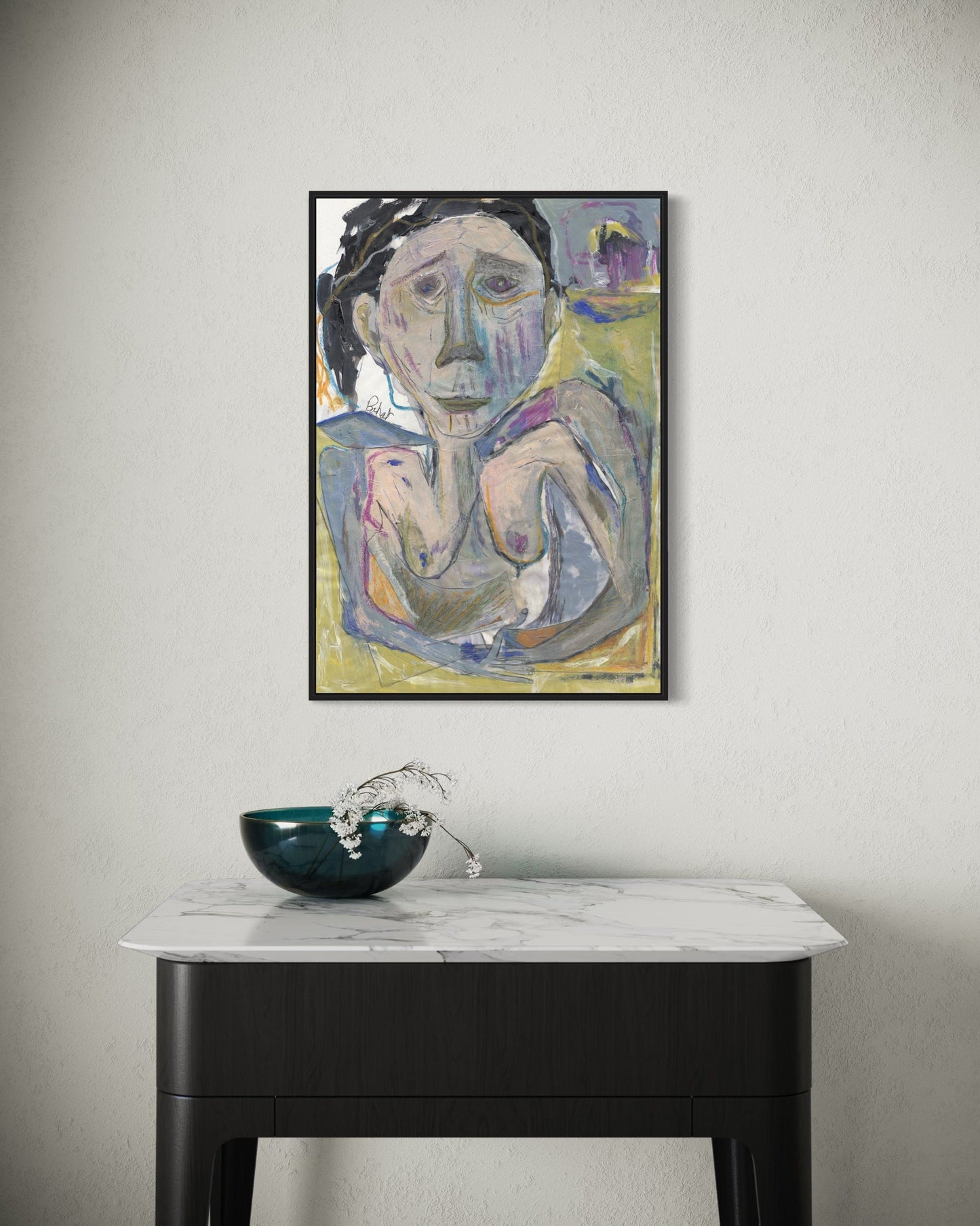 Framed abstract painting on a wall above a marble table with a decorative bowl.