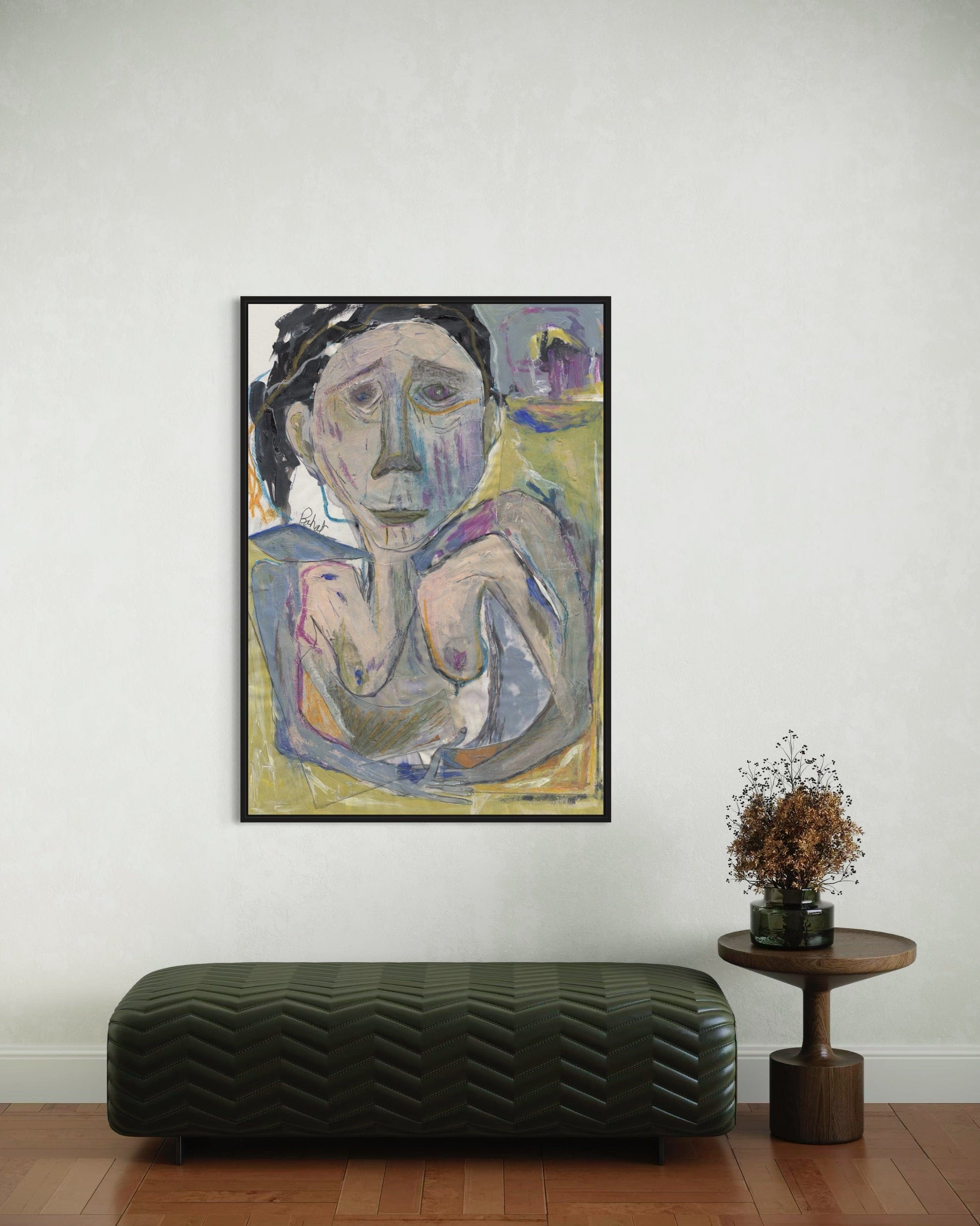 Framed abstract painting on a wall above a bench and small table with a plant.
