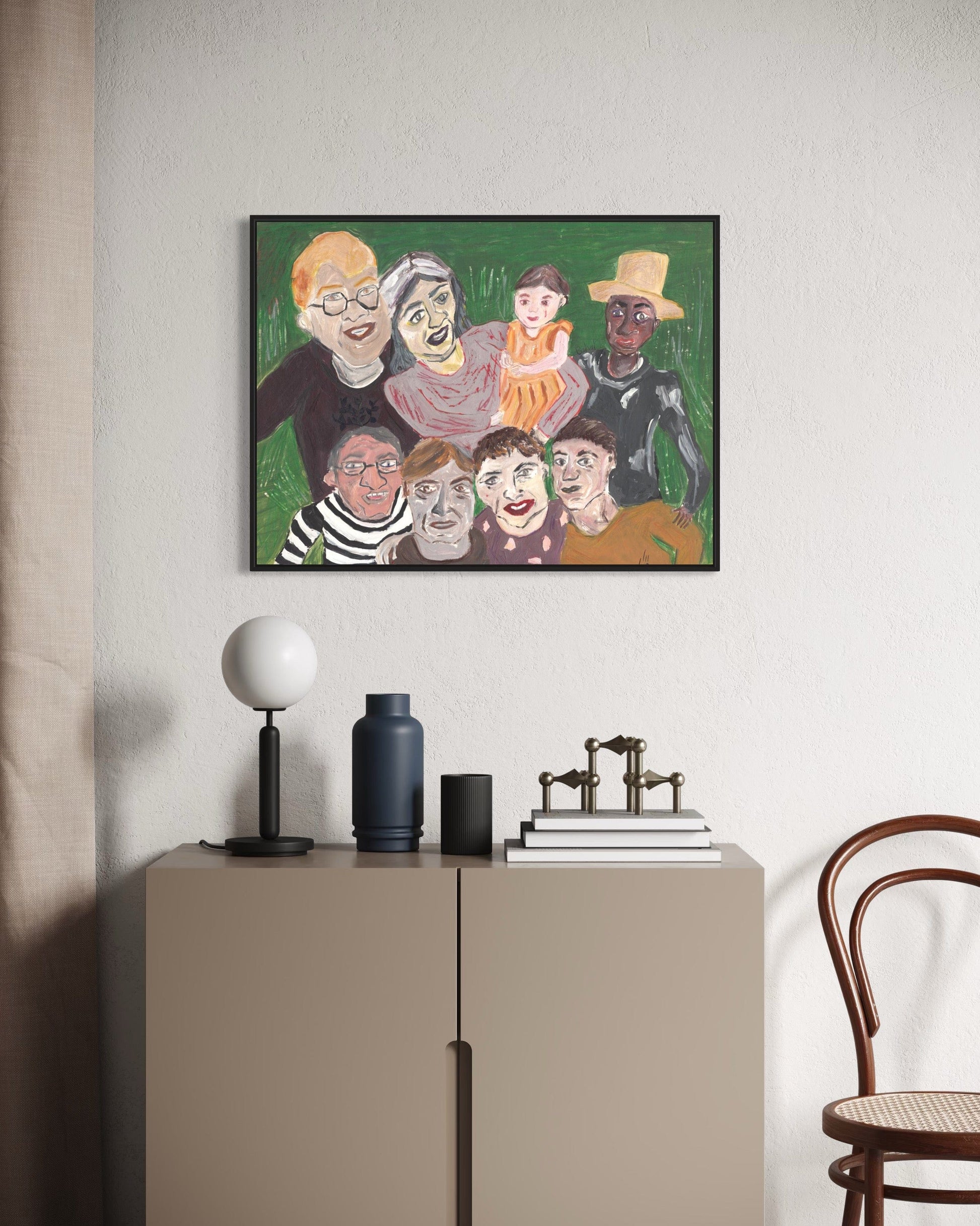 Framed artwork of stylized faces on a wall above a cabinet with decorative items.